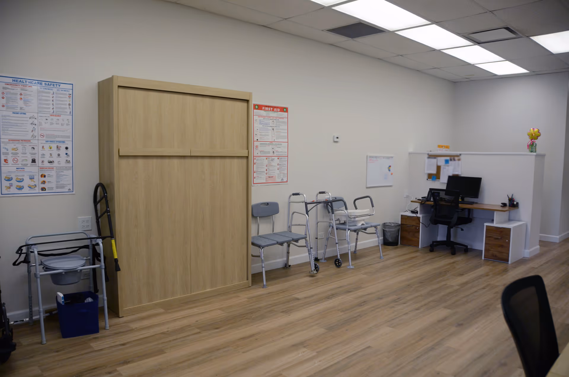 Empty interior of a senior facility showing chairs, walker, and a desk.