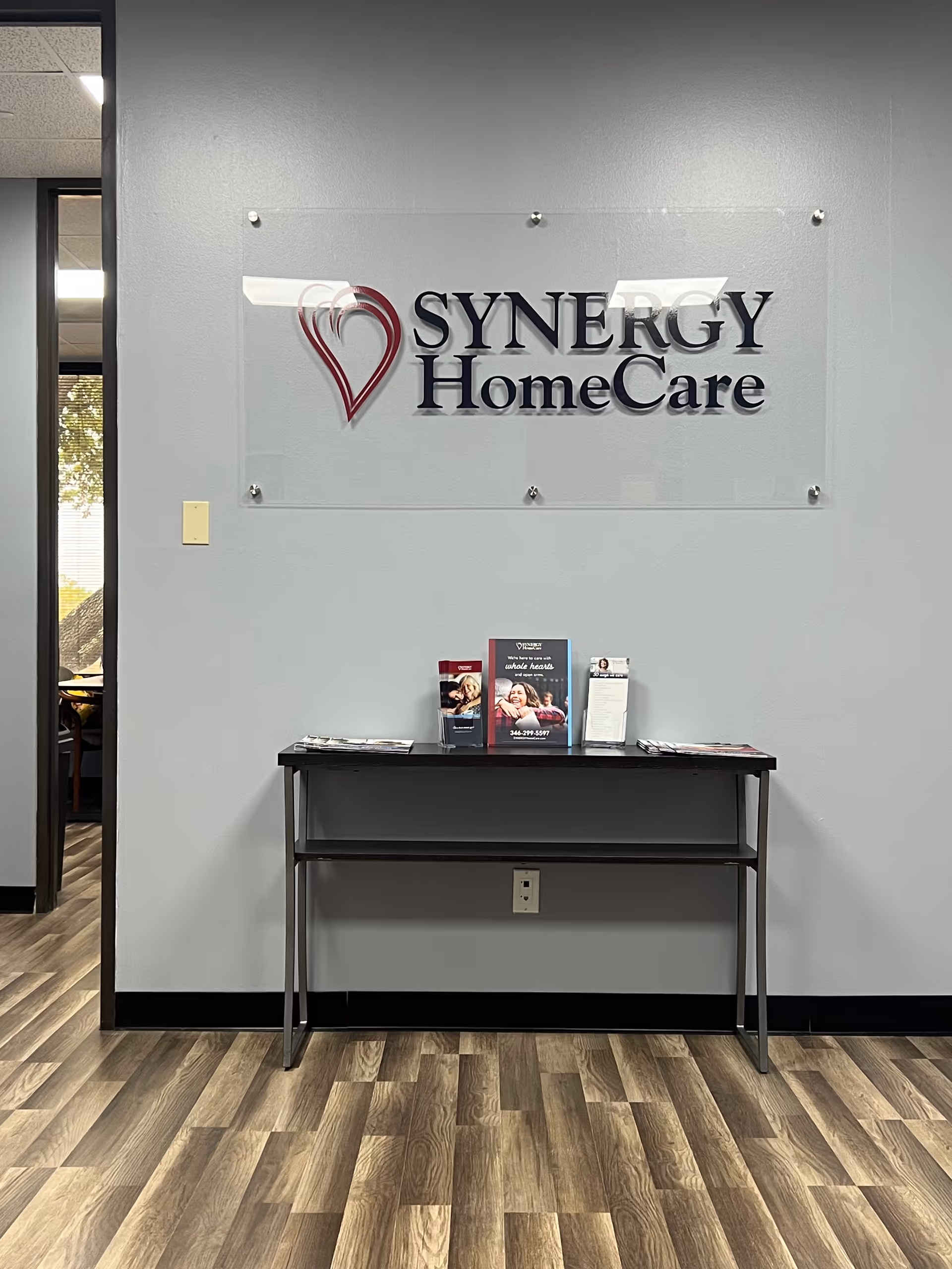Interior lobby scene featuring Synergy HomeCare sign and a brochure table.