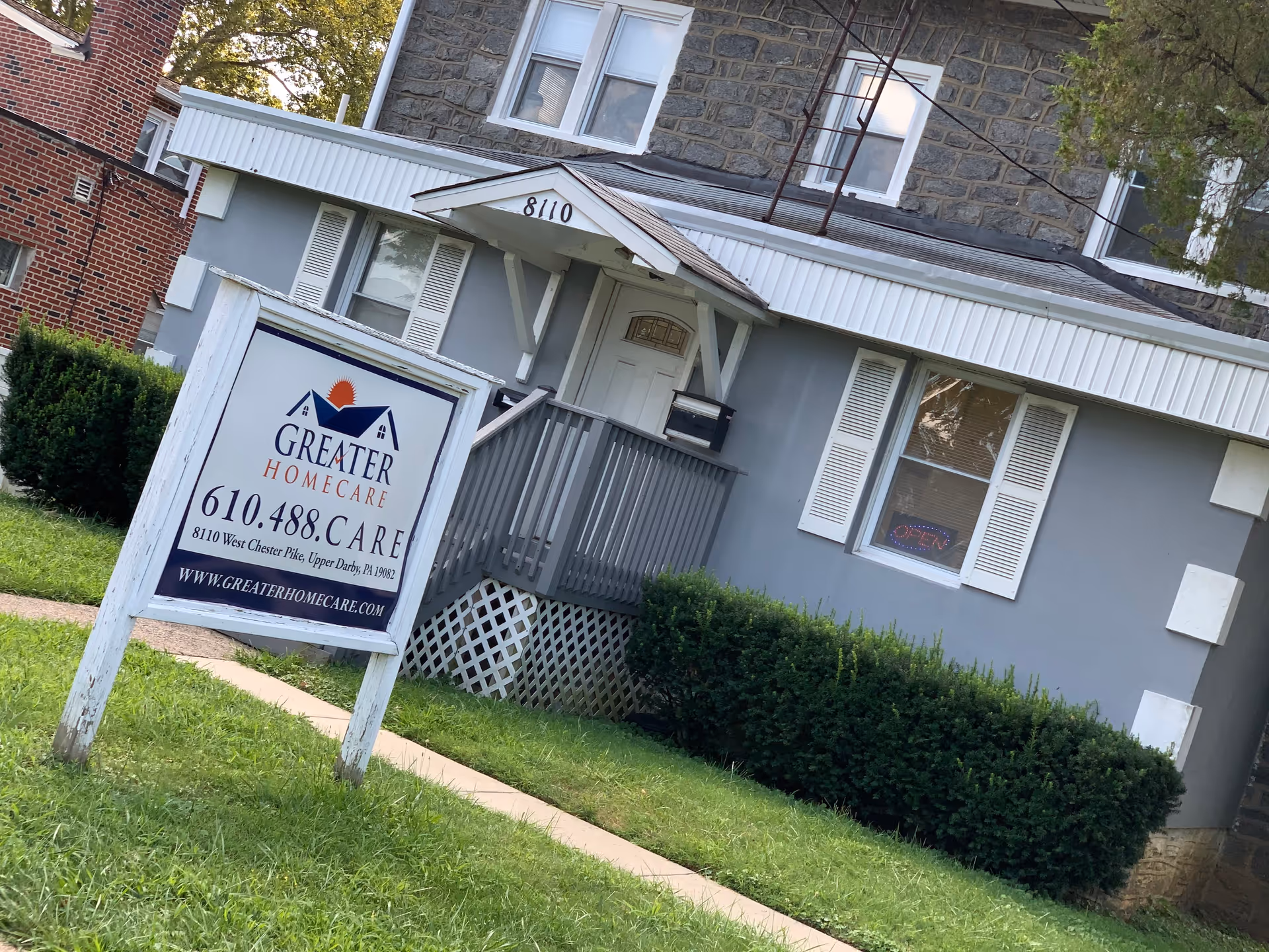 Front exterior of a gray senior care facility with a Greater Homecare sign.