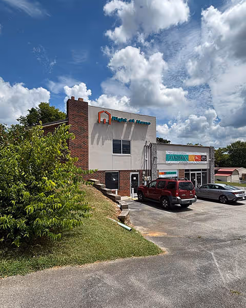 Exterior view of a Right at Home building with parked cars in the lot.