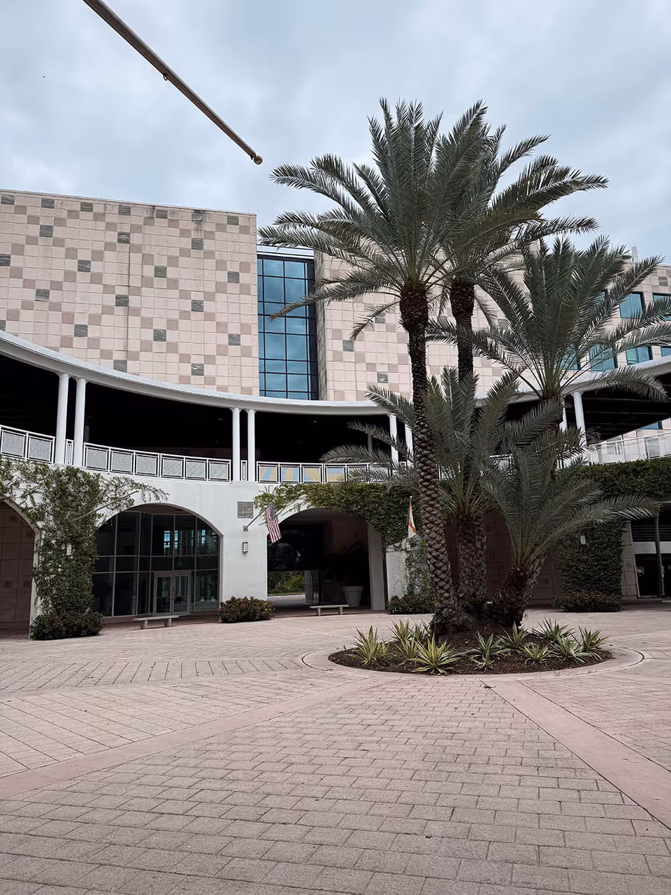 Exterior view of Right at Home senior living facility with palm trees and a paved courtyard.