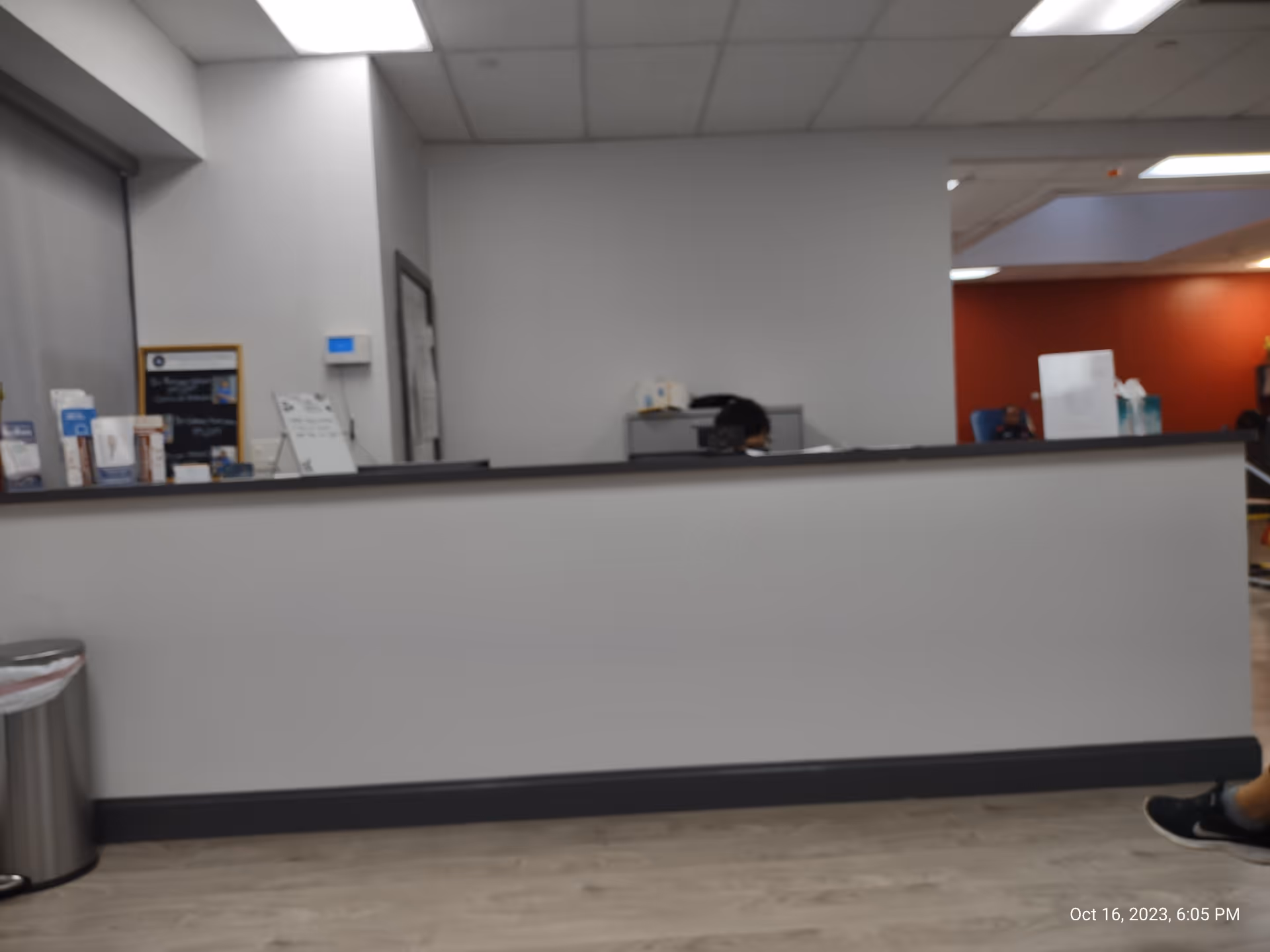 Reception desk inside a clinical lobby with brochures and a staff member behind the counter.