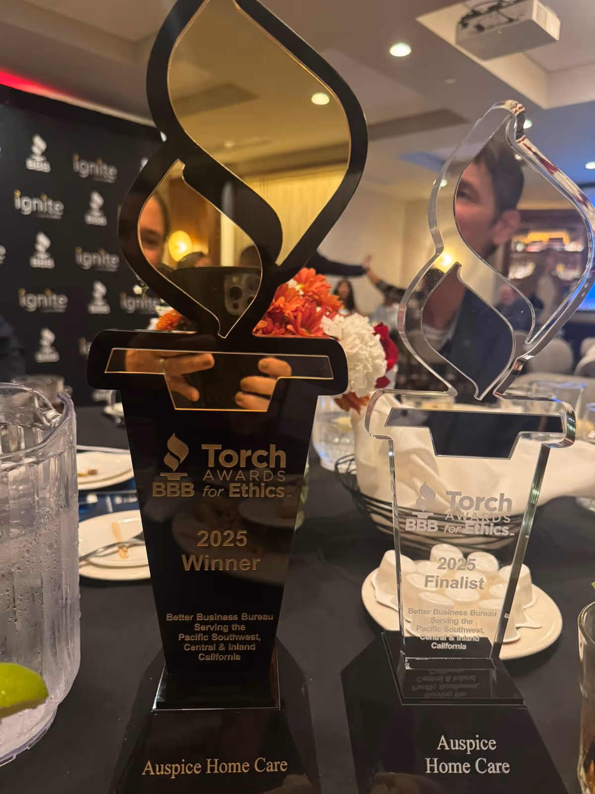 Close-up of Torch Awards trophies on a table at an indoor event.