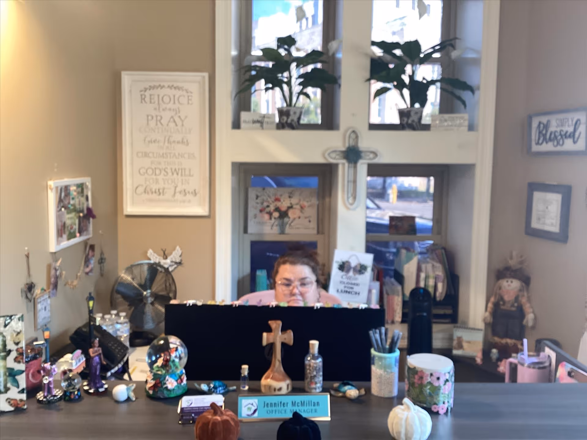 Reception area inside a senior living facility with a desk, decor, and a staff member.