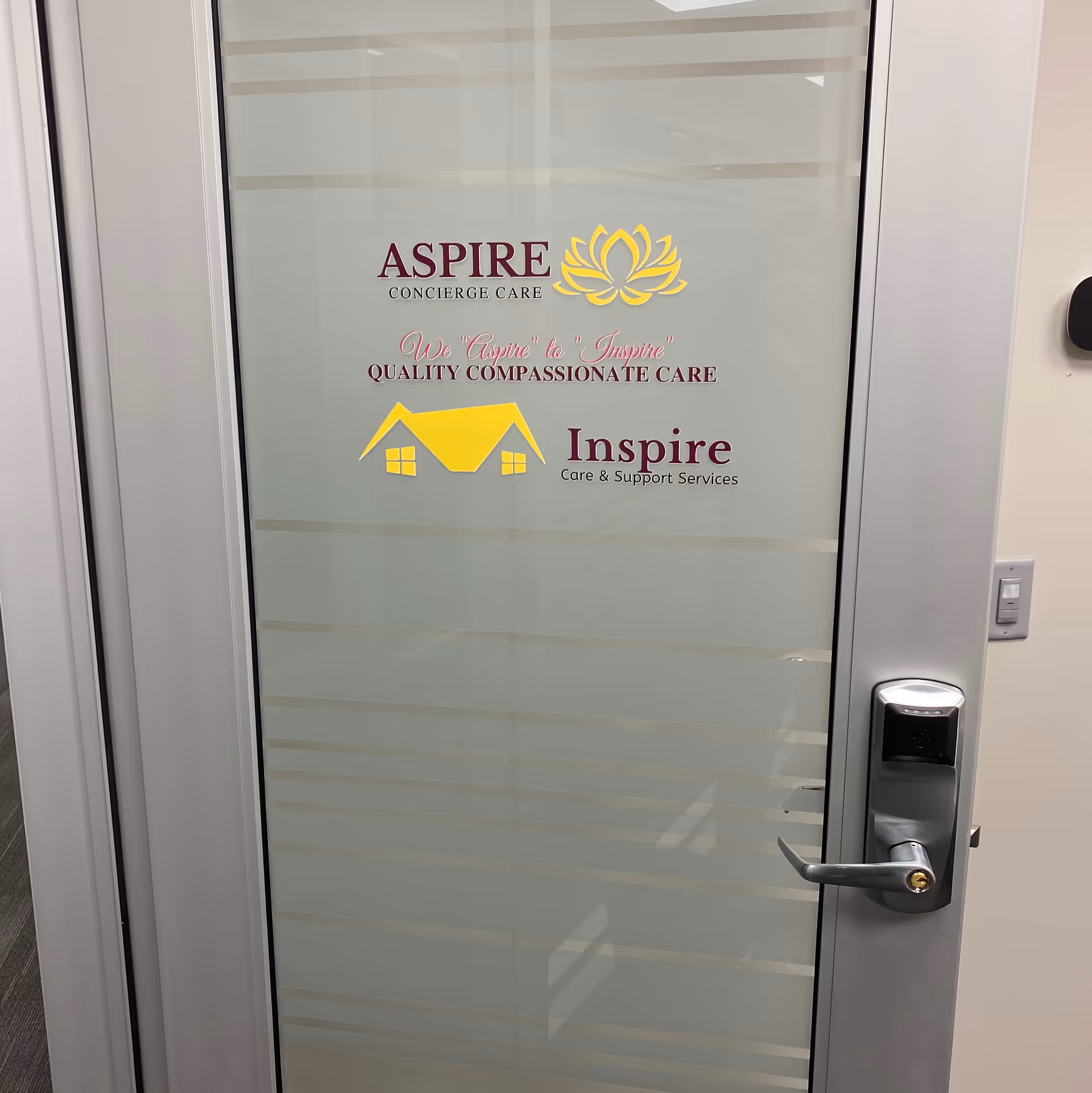 Glass door displaying Aspire Concierge Care logo in a modern interior.