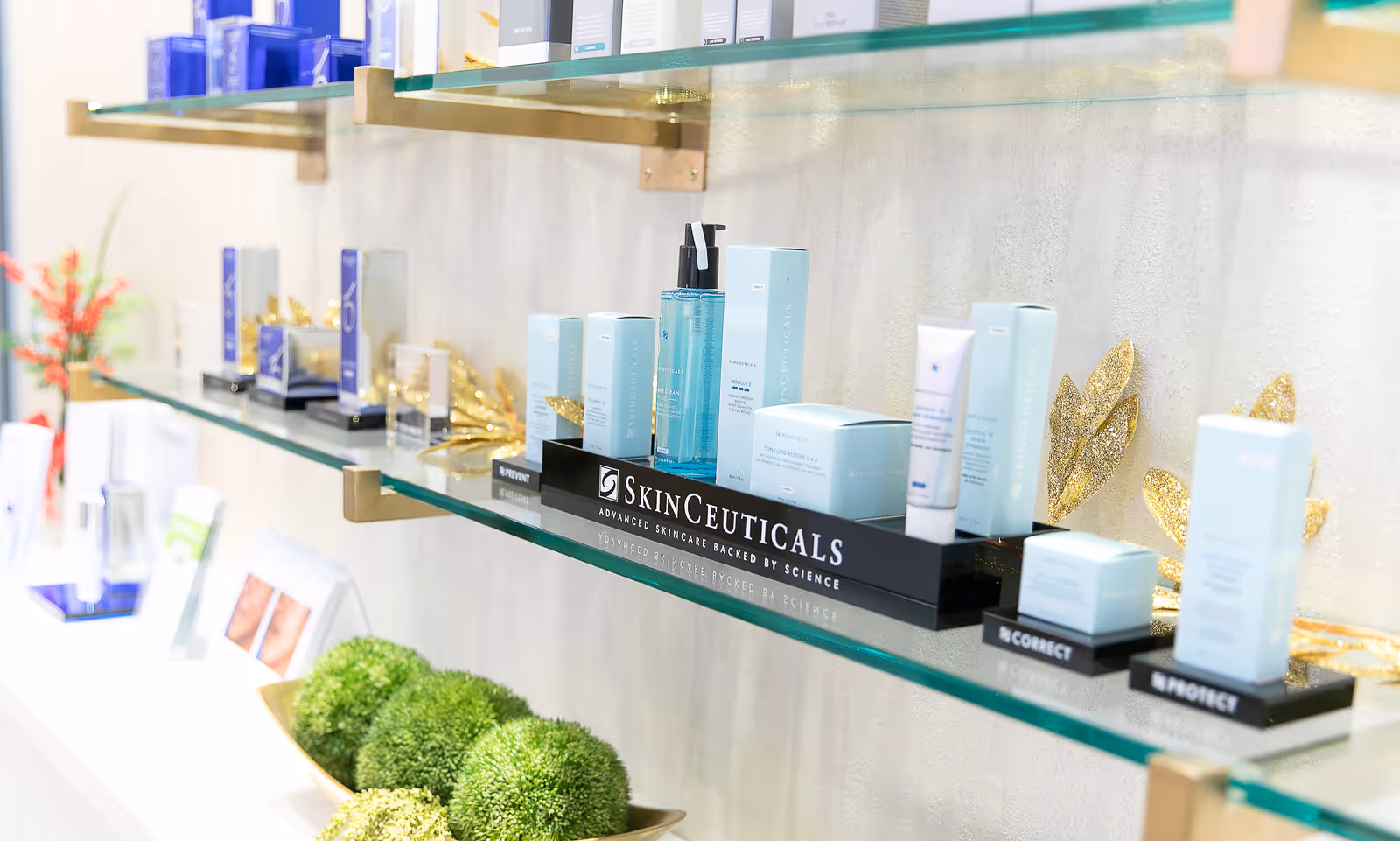 Display of skincare products on glass shelves in a bright spa-like interior.