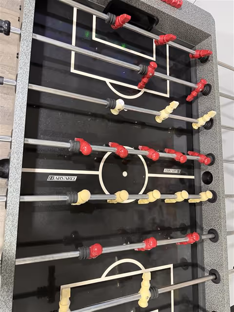 Foosball table in indoor recreational area with red and yellow players.