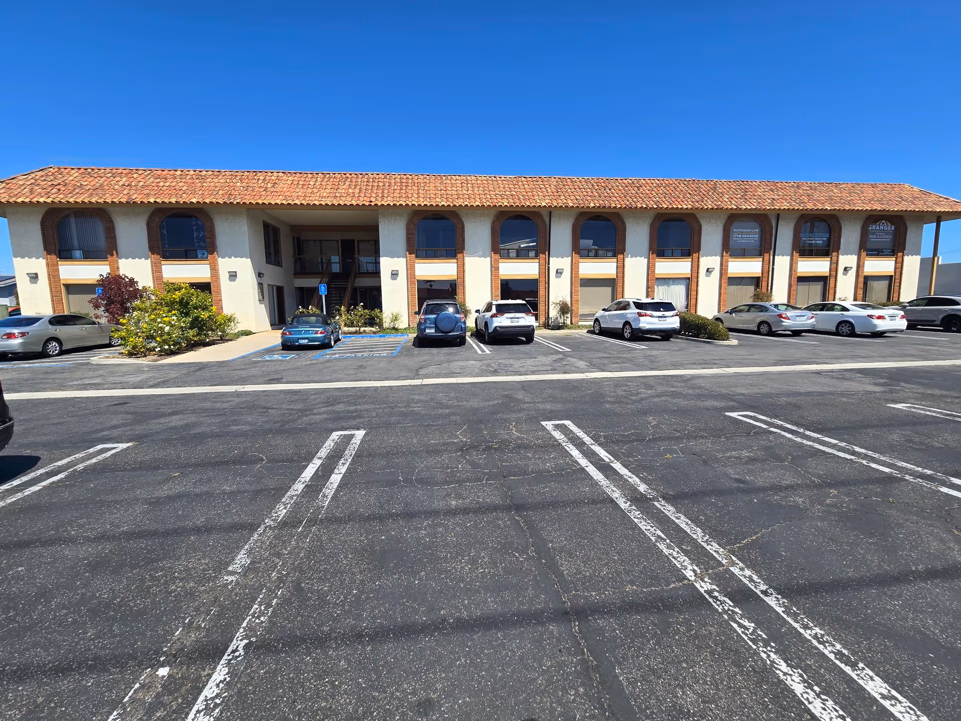 Exterior view of Homewatch CareGivers of Huntington Newport Beach building with cars in front.