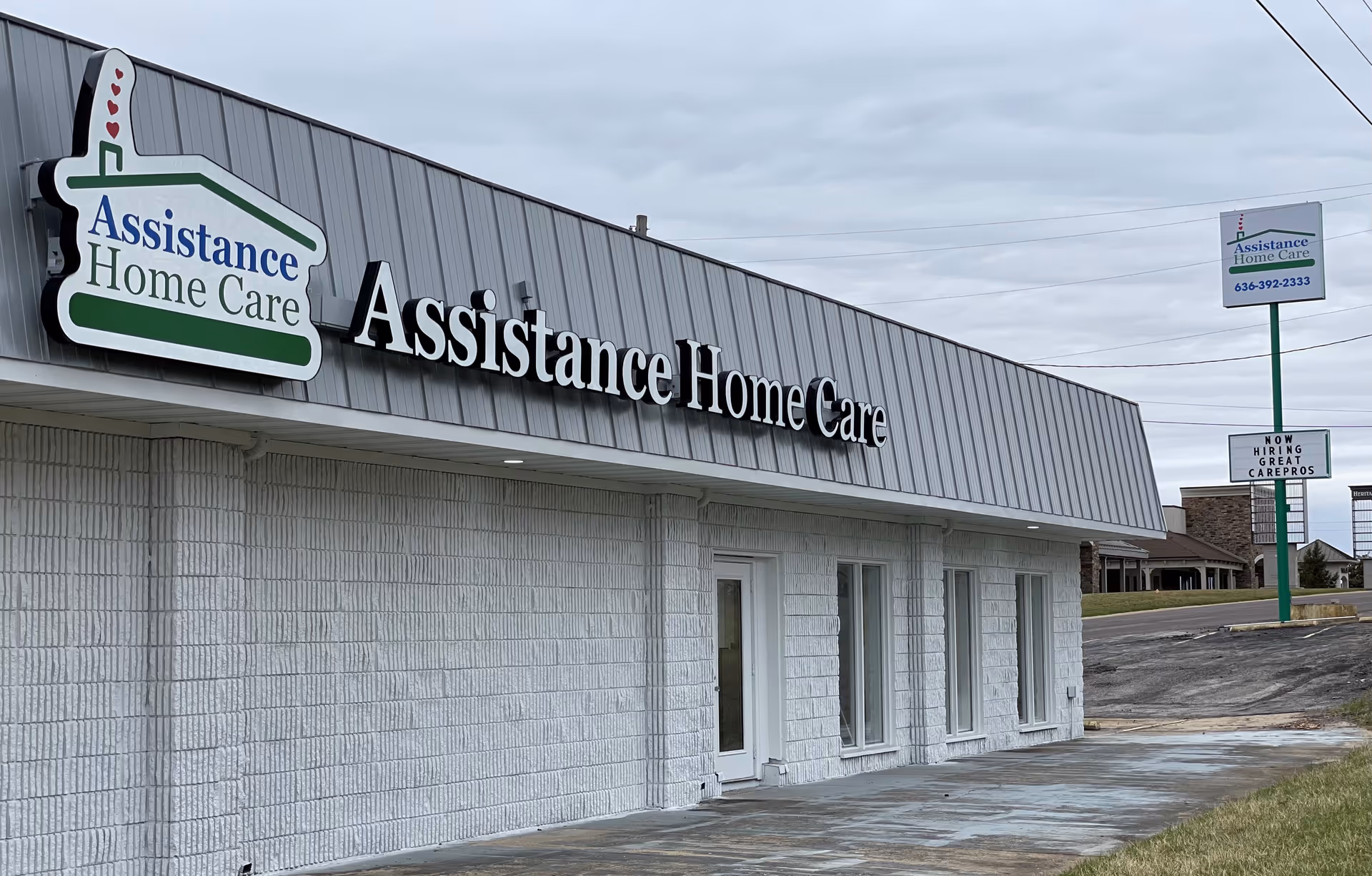 Exterior of Assistance Home Care building with prominent sign and glass entrance