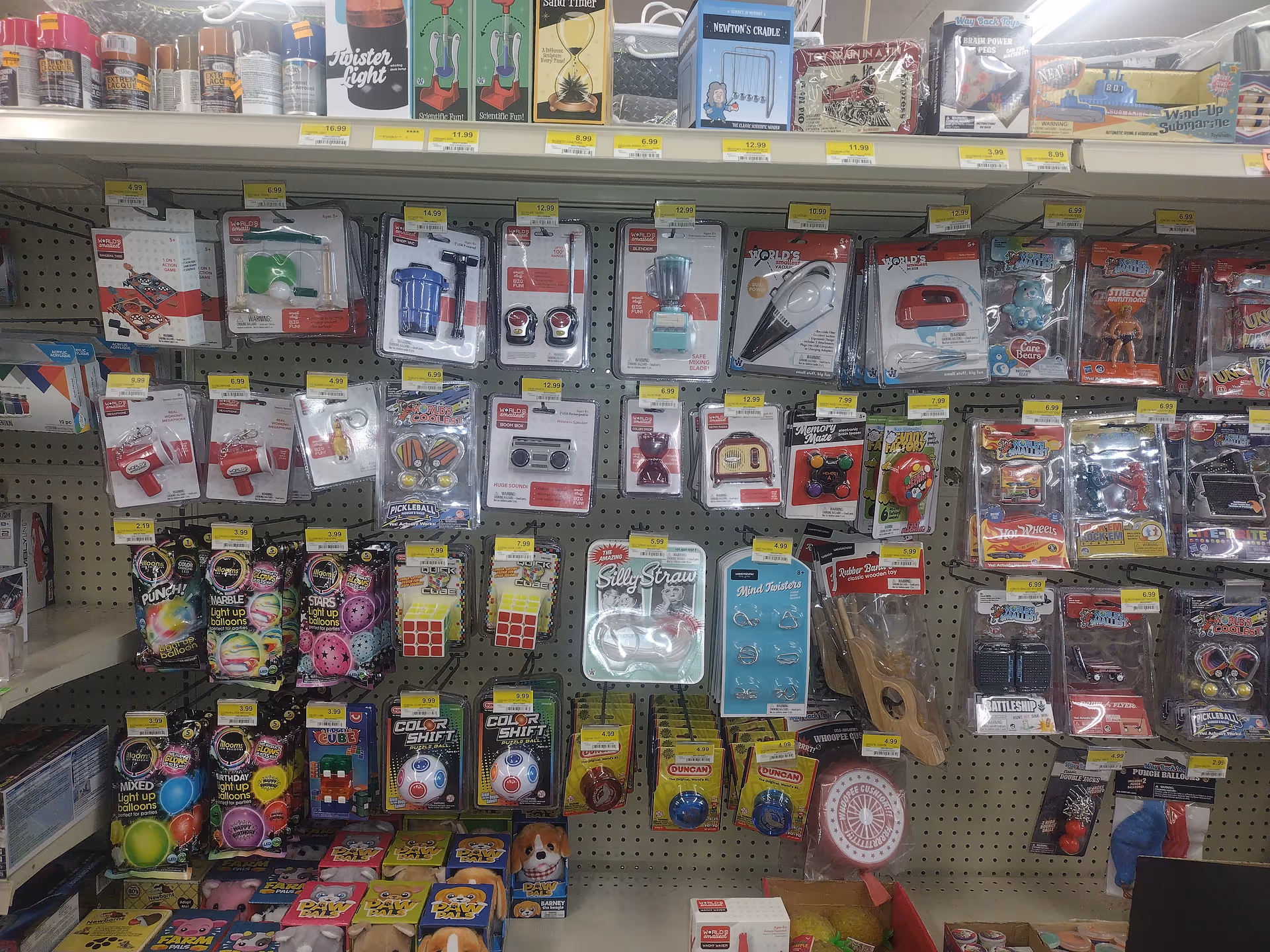 View of pegboard shelves filled with assorted toy and gadget packaging in a discount store.