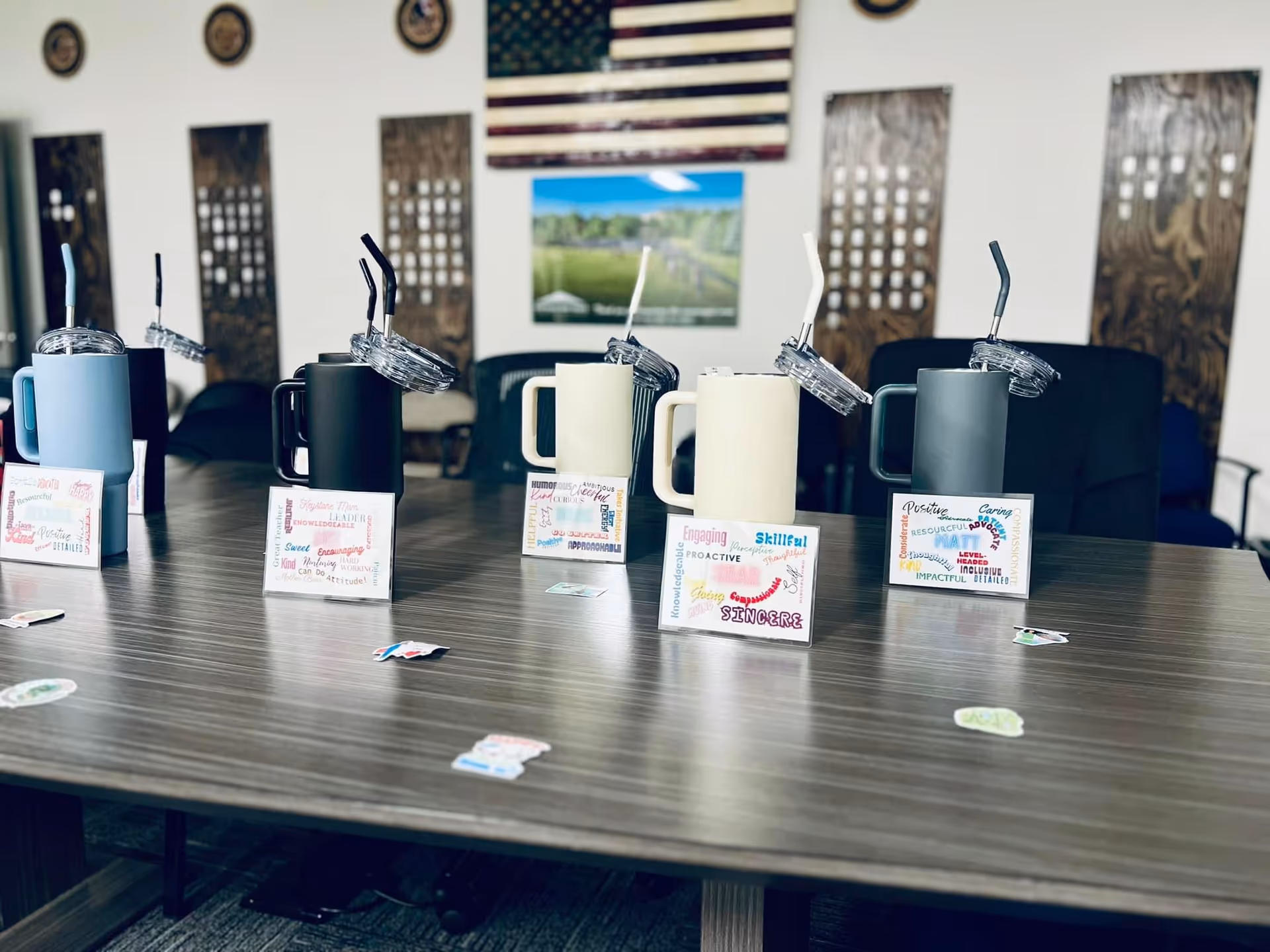 A long table with several tumblers and word cards in a meeting room.