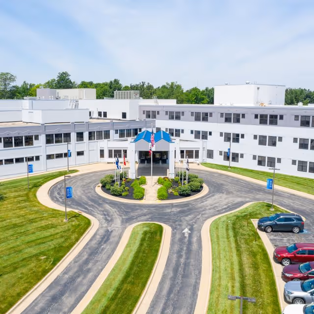 Aerial view of Highland District Hospital's white building with a circular driveway and parking.