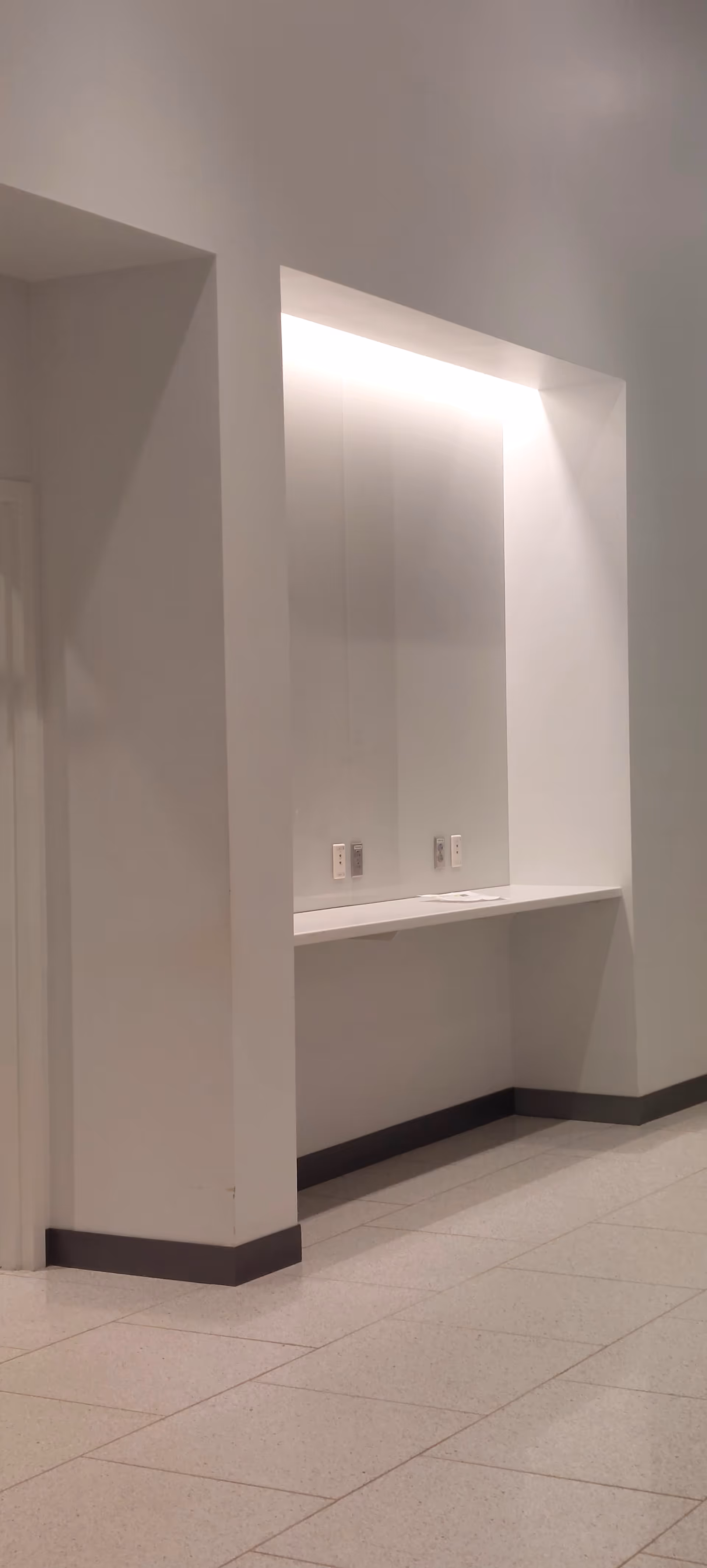 White interior featuring a recessed alcove with a counter and outlets.