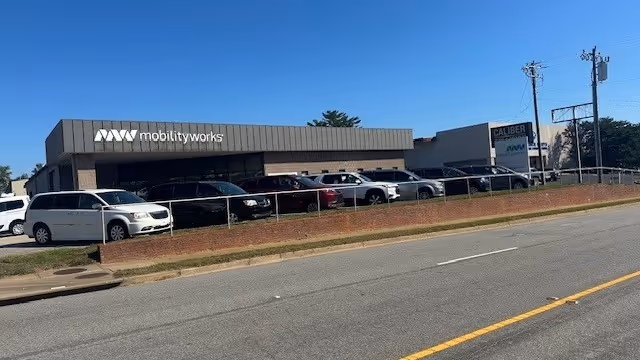 Exterior view of MobilityWorks building with parked cars along the storefront.