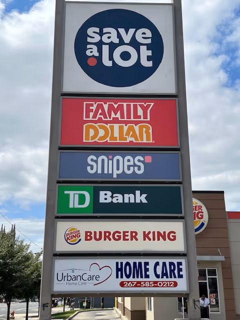 Outdoor storefront signboard displaying multiple business logos including UrbanCare Home Care.
