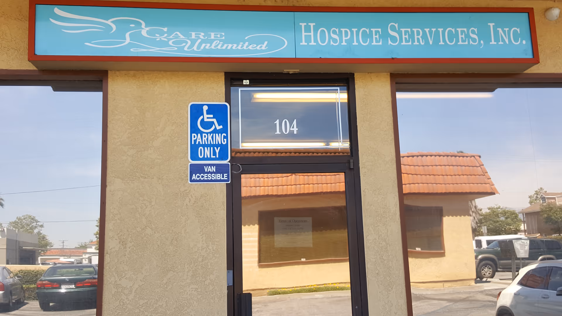Exterior view of Care Unlimited Hospice Services building entrance with a handicap parking sign