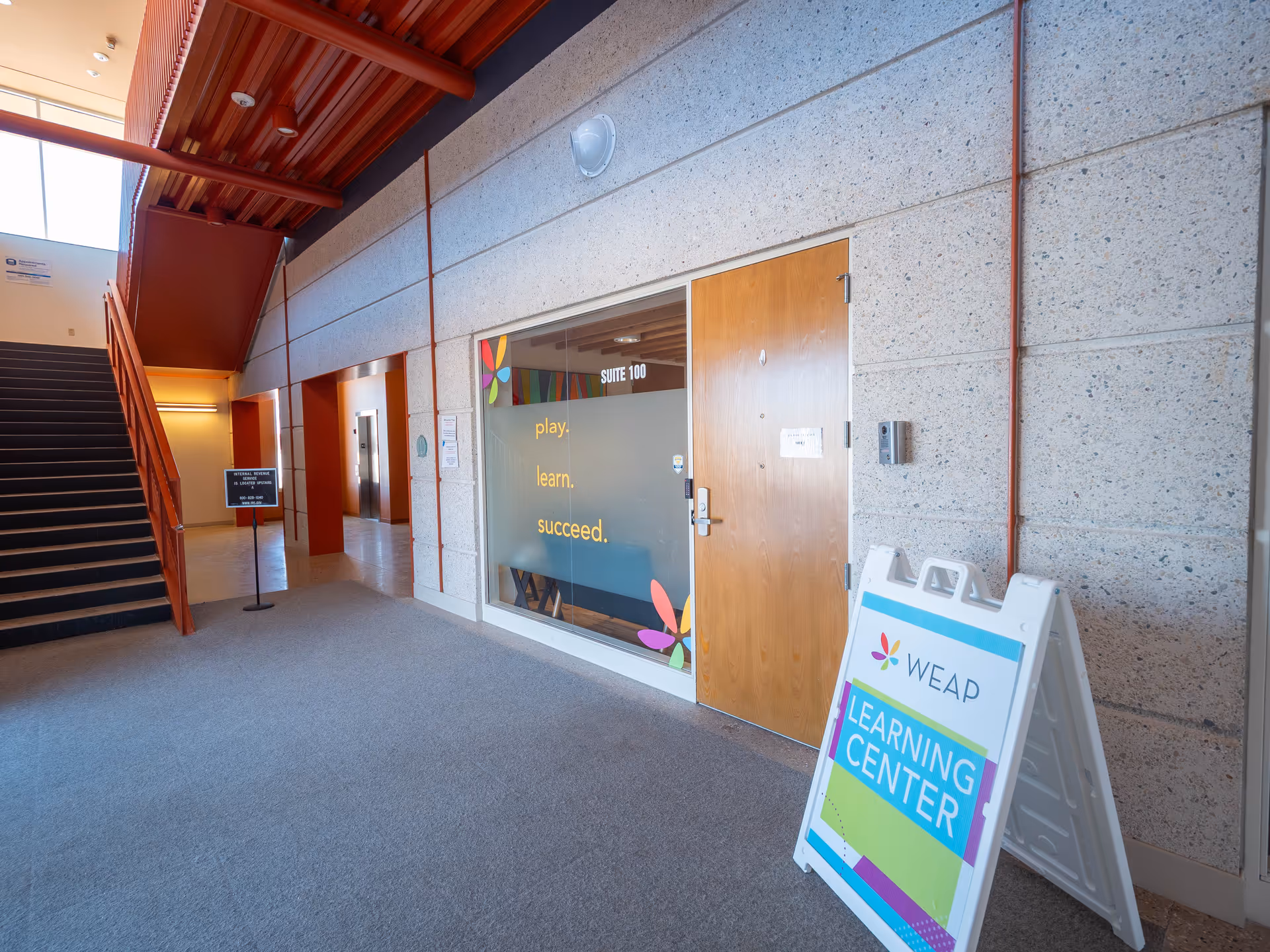 Interior hallway of WEAP building with a learning center sign and stairs.