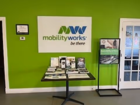 Bright green wall with MobilityWorks logo and brochure table in lobby area