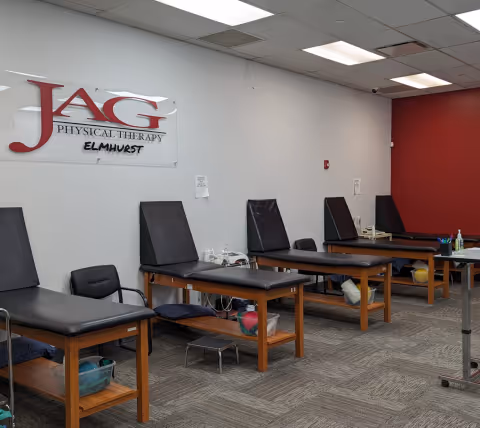 Treatment tables and chairs line a clinic room inside JAG Physical Therapy Elmhurst.