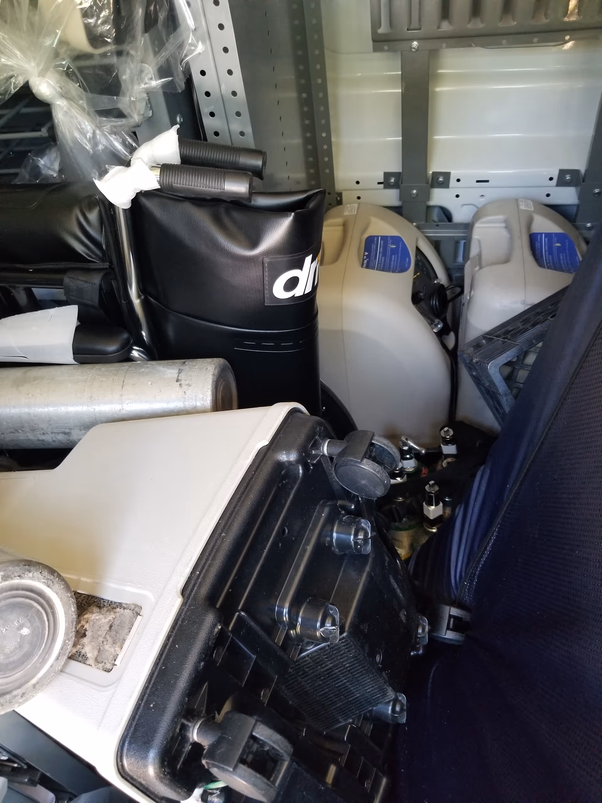 Cluttered interior storage area containing medical equipment, hoses, and devices.