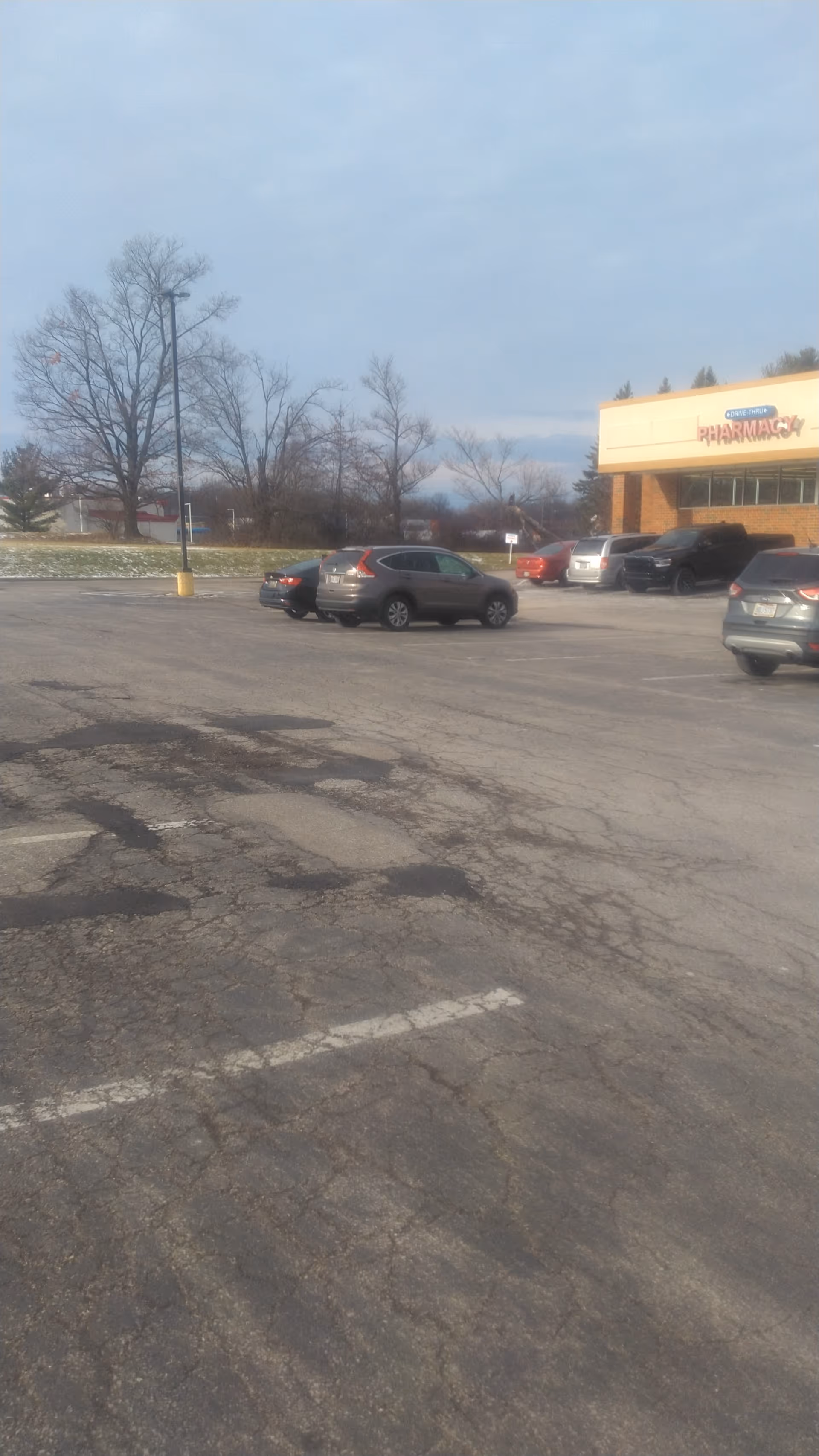 Exterior view of Discount Drug Mart storefront with cars in a large parking lot