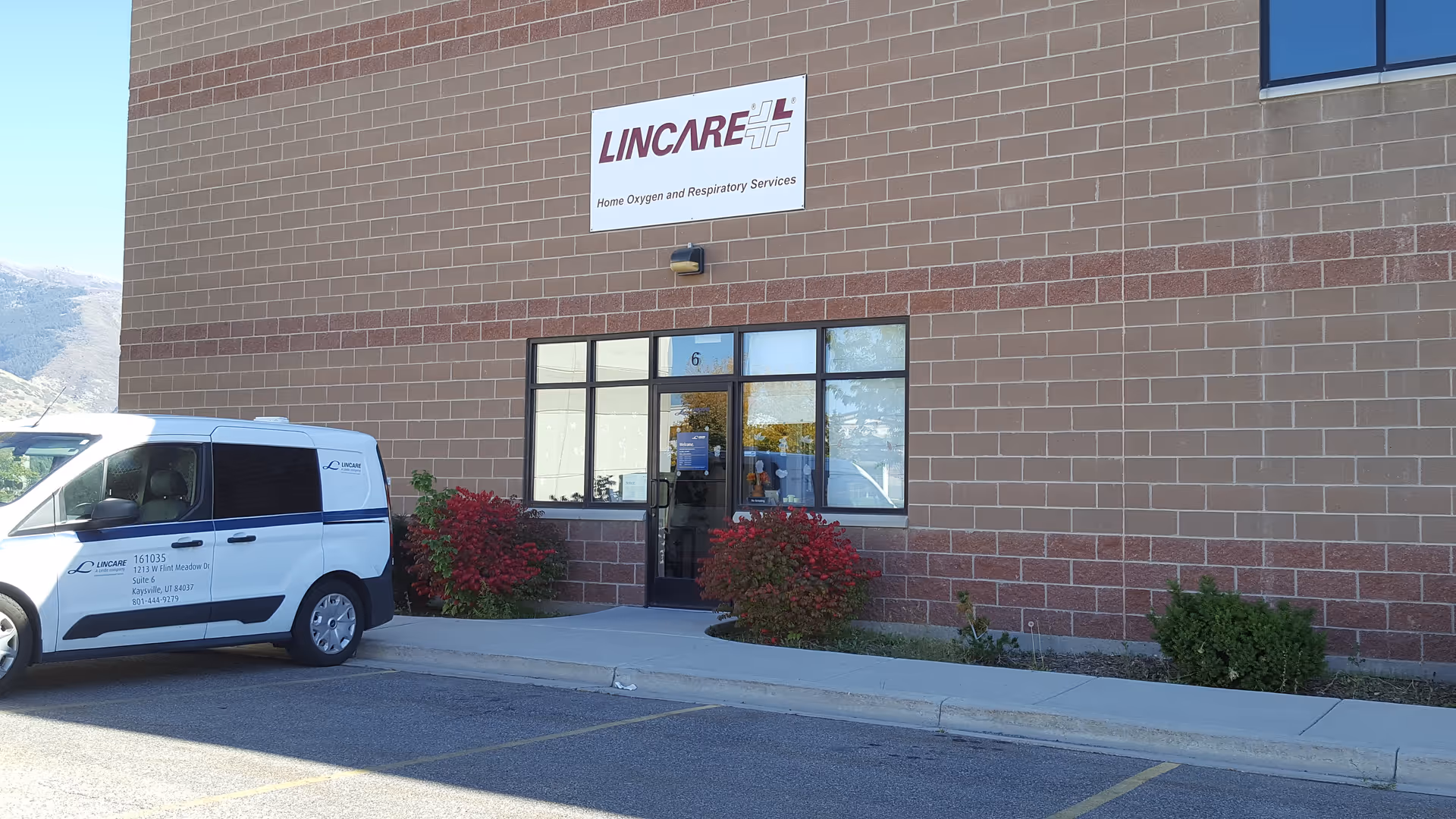 Brick building exterior with Lincare sign, large entrance, and a white service van parked outside.