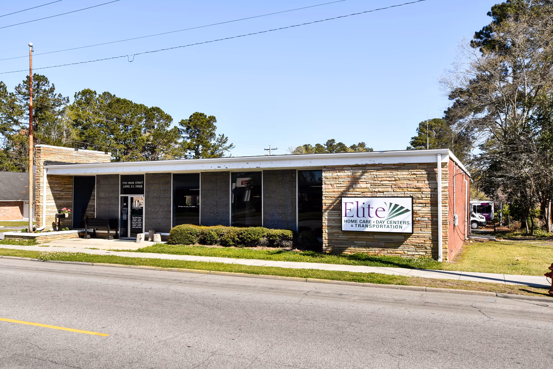 Exterior of a single-story facility with stone facade and Elite Home Care sign.