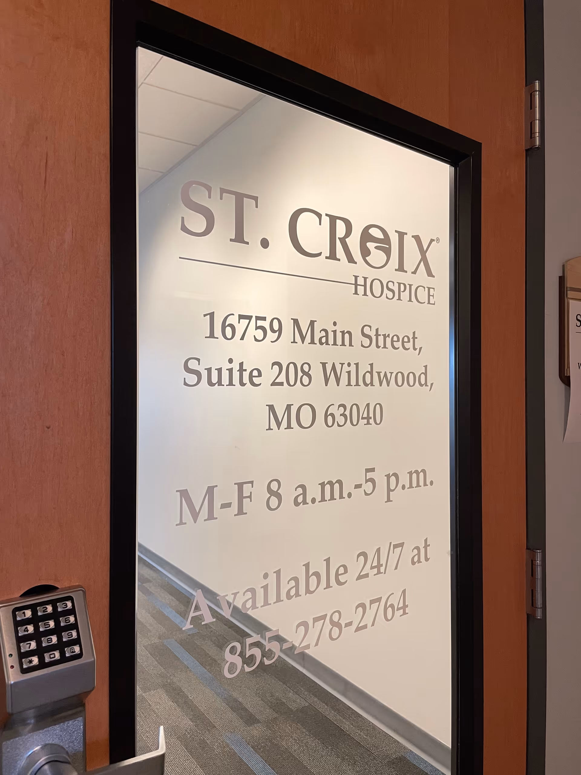 Interior doorway with frosted glass sign reading St. Croix Hospice and address details.