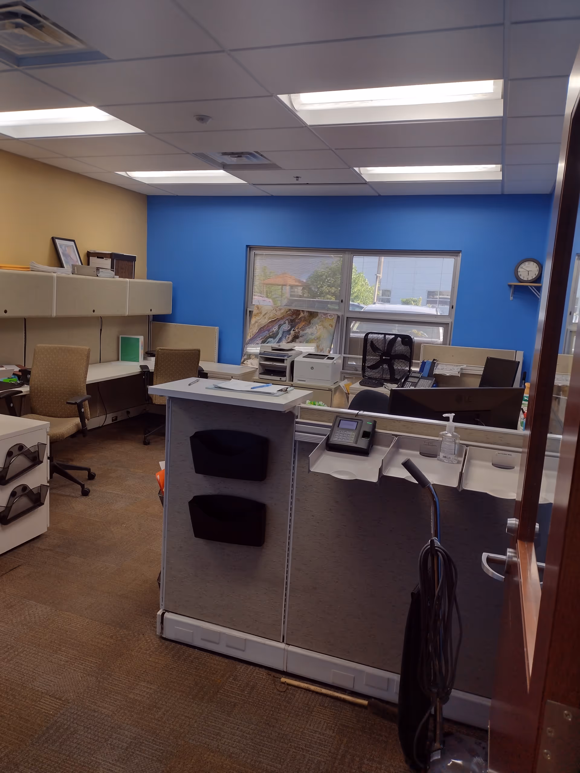 Reception desk area with computers and blue wall in an office-like interior.