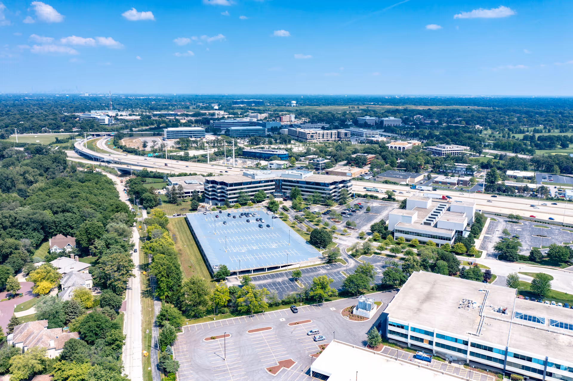 Aerial view of a multi-building campus with parking lots and surrounding roads.