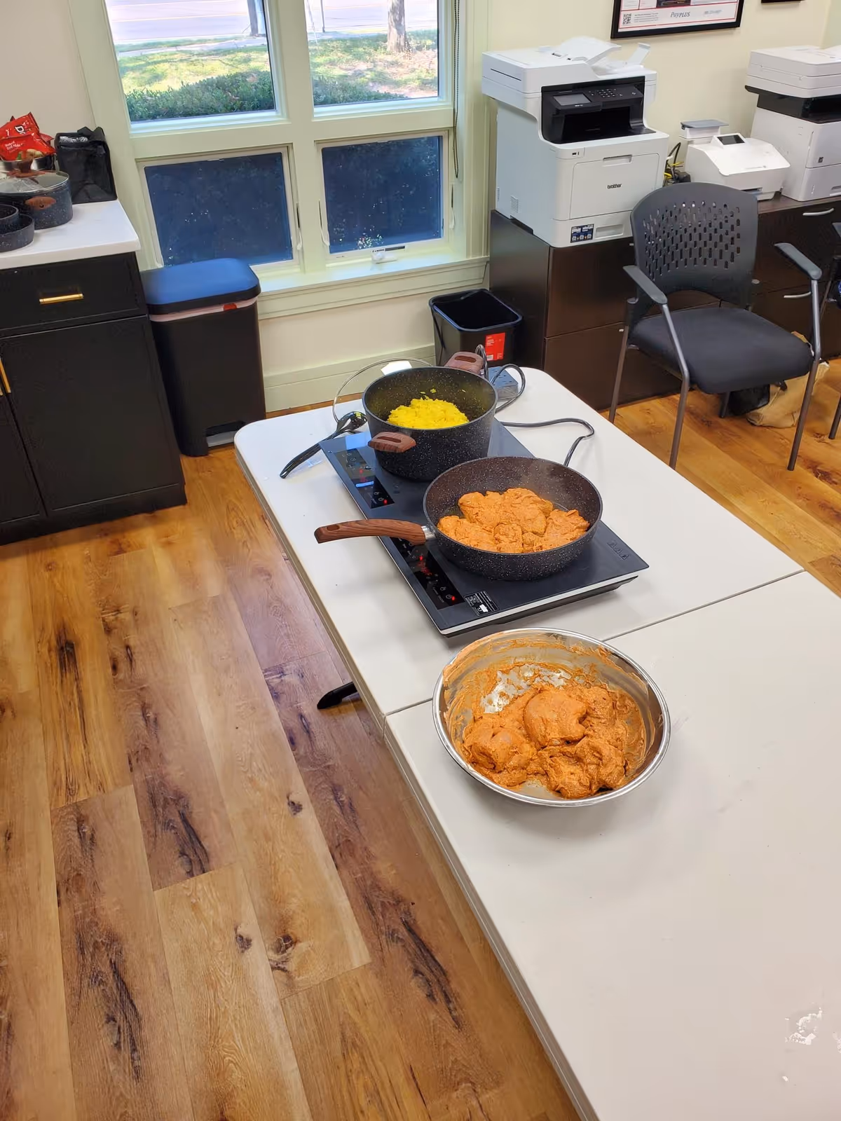 A kitchen workspace with two pots on an induction stove and mixing bowl.