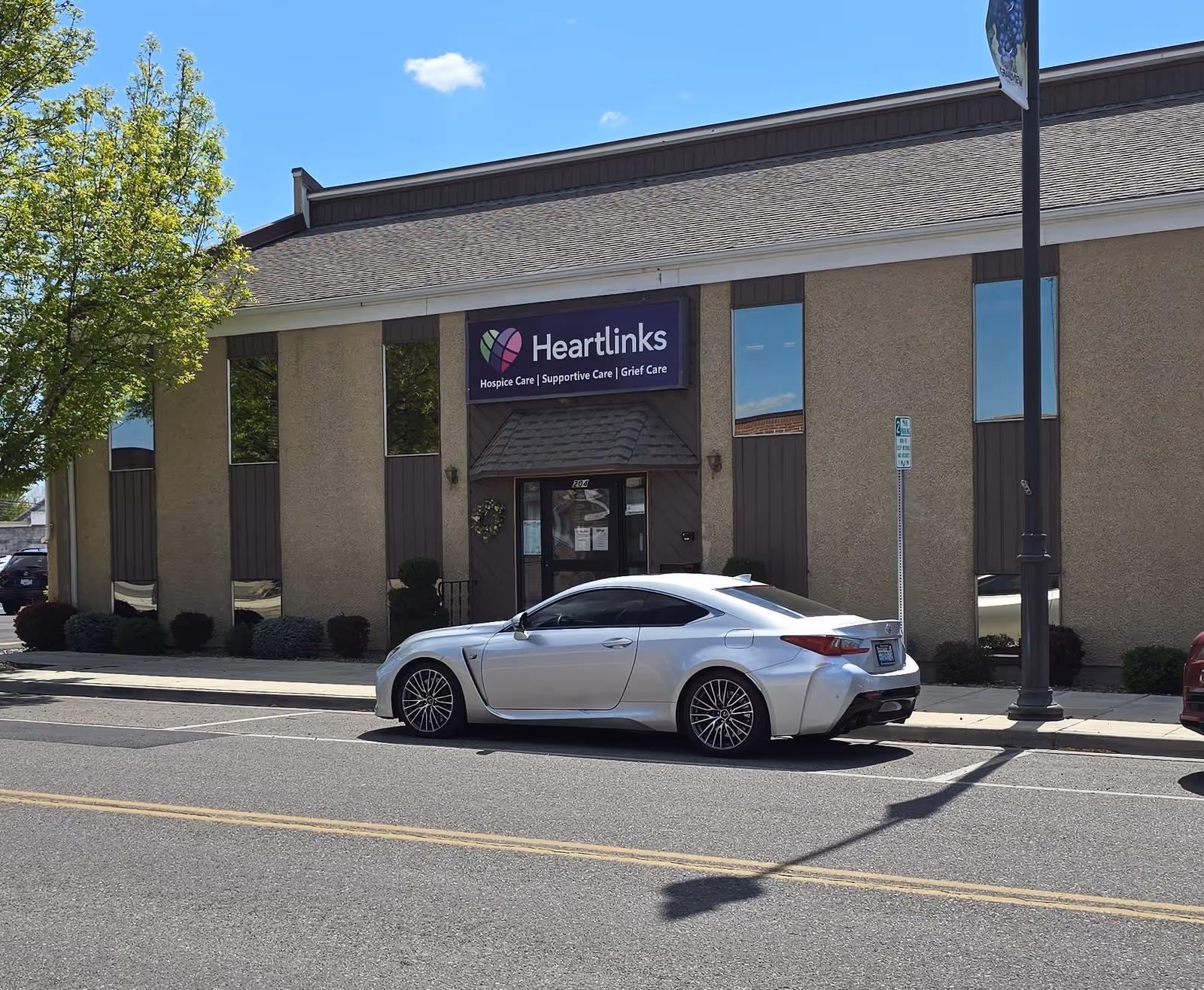 Exterior view of Heartlinks facility with a white sports car parked in front.