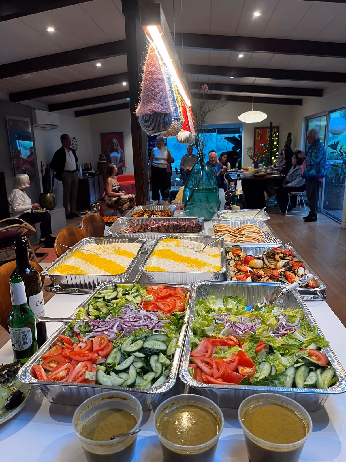 Buffet tables with colorful salads and dishes arranged in a communal dining room.