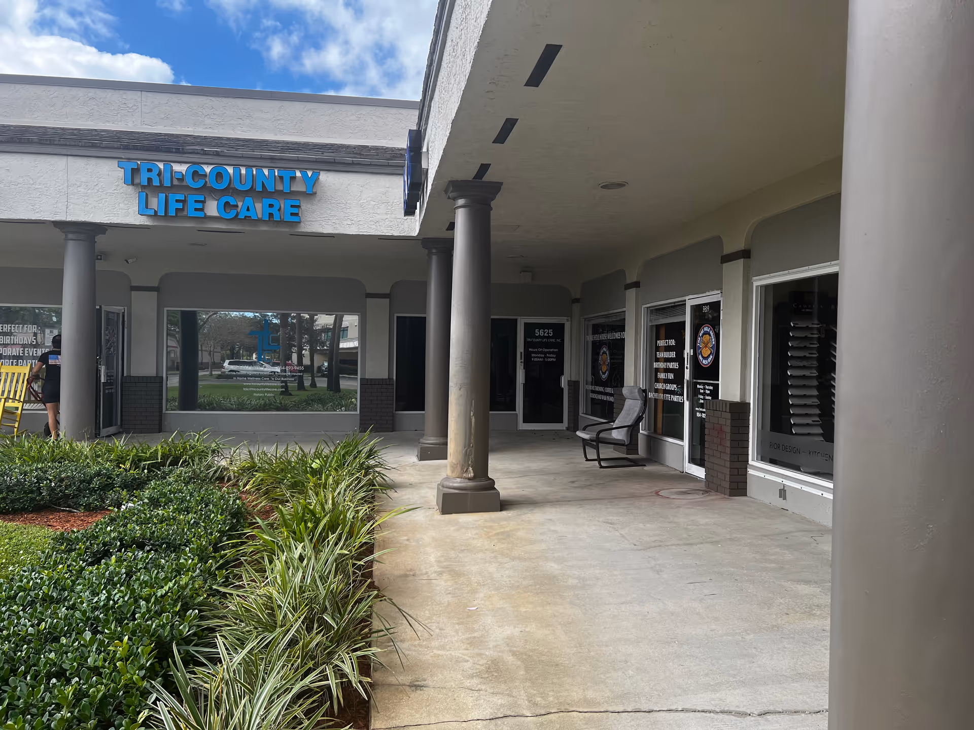 Exterior view of Tri-County Life Care entrance with columns and greenery.