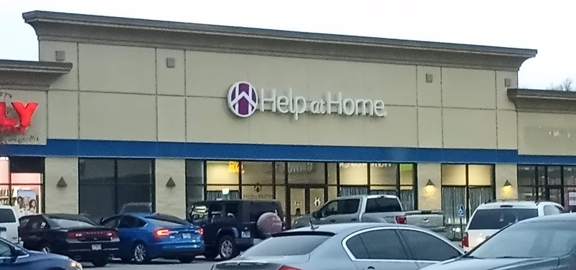 Exterior view of a Help at Home facility with parked cars in front