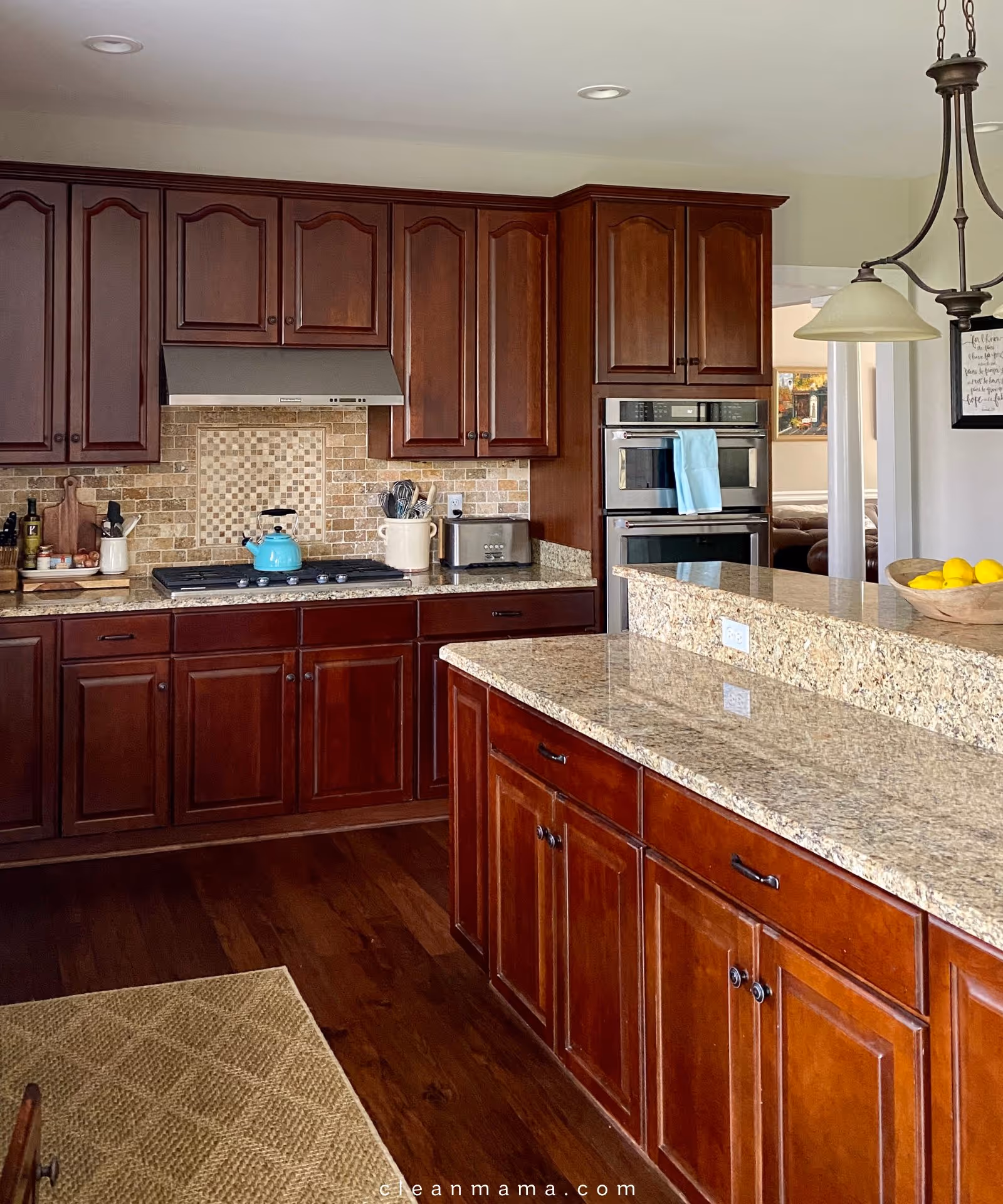 A spacious kitchen with dark wood cabinets, granite countertops, and a central island.