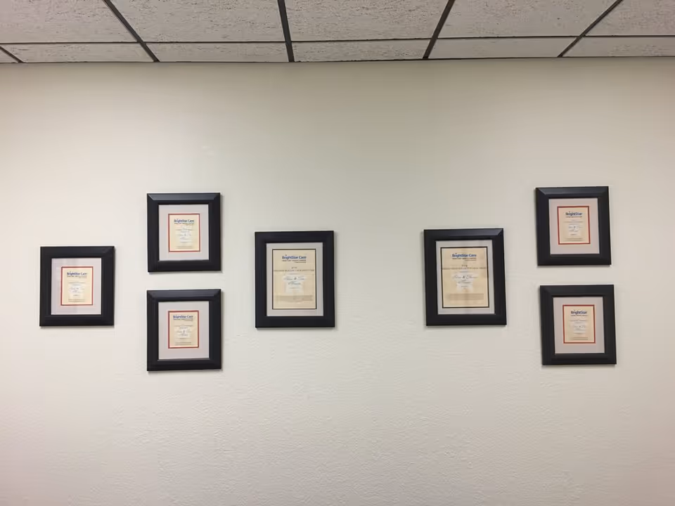 White interior wall with several framed certificates arranged in two clusters.