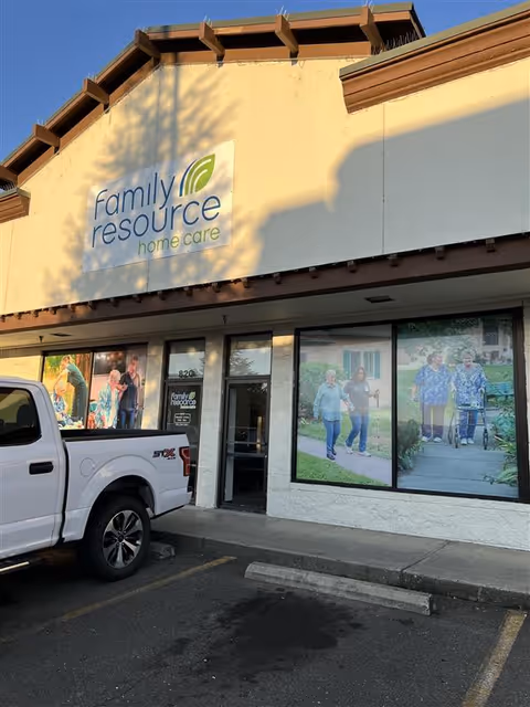 Exterior view of a Family Resource Home Care storefront with windows and a parked white truck