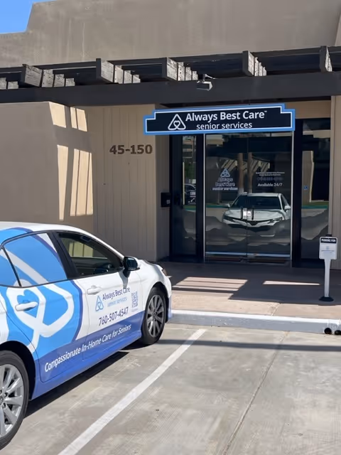 Entrance of Always Best Care Senior Services in Palm Desert, with a branded company car nearby.