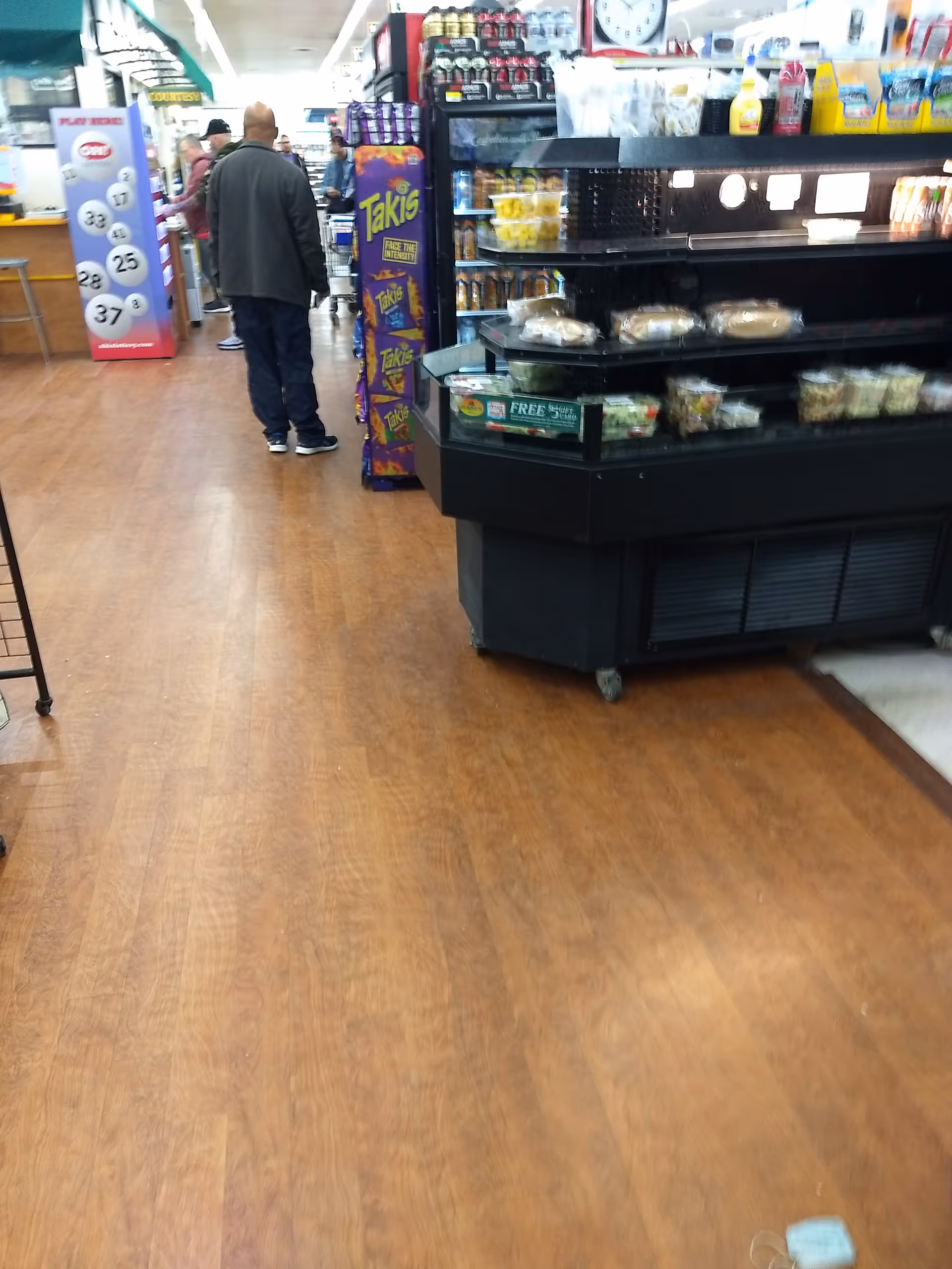 Inside Discount Drug Mart, customers stand near a checkout counter with shelves and displays.