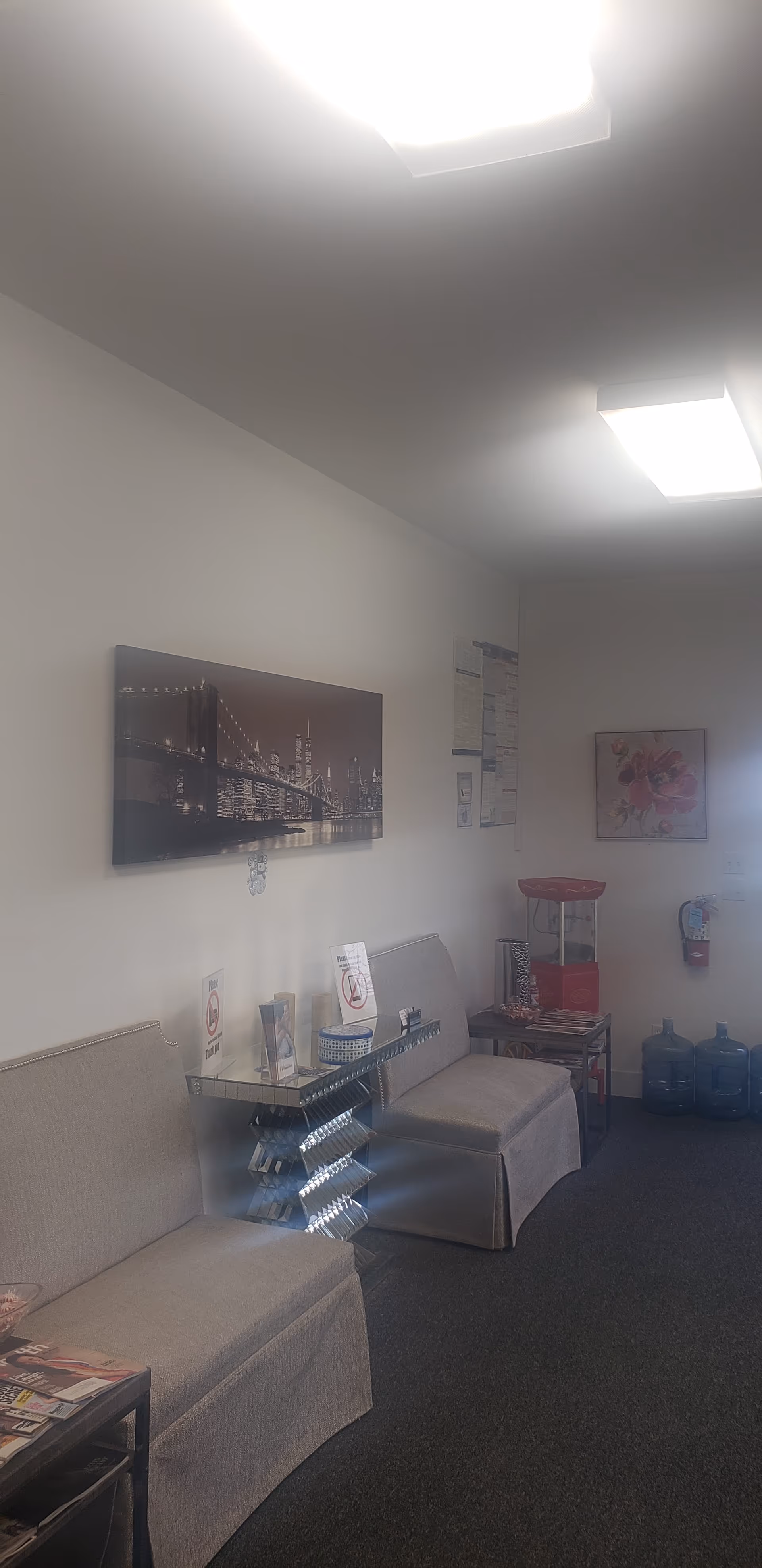 Interior waiting area in a senior care facility with beige couches and wall art.