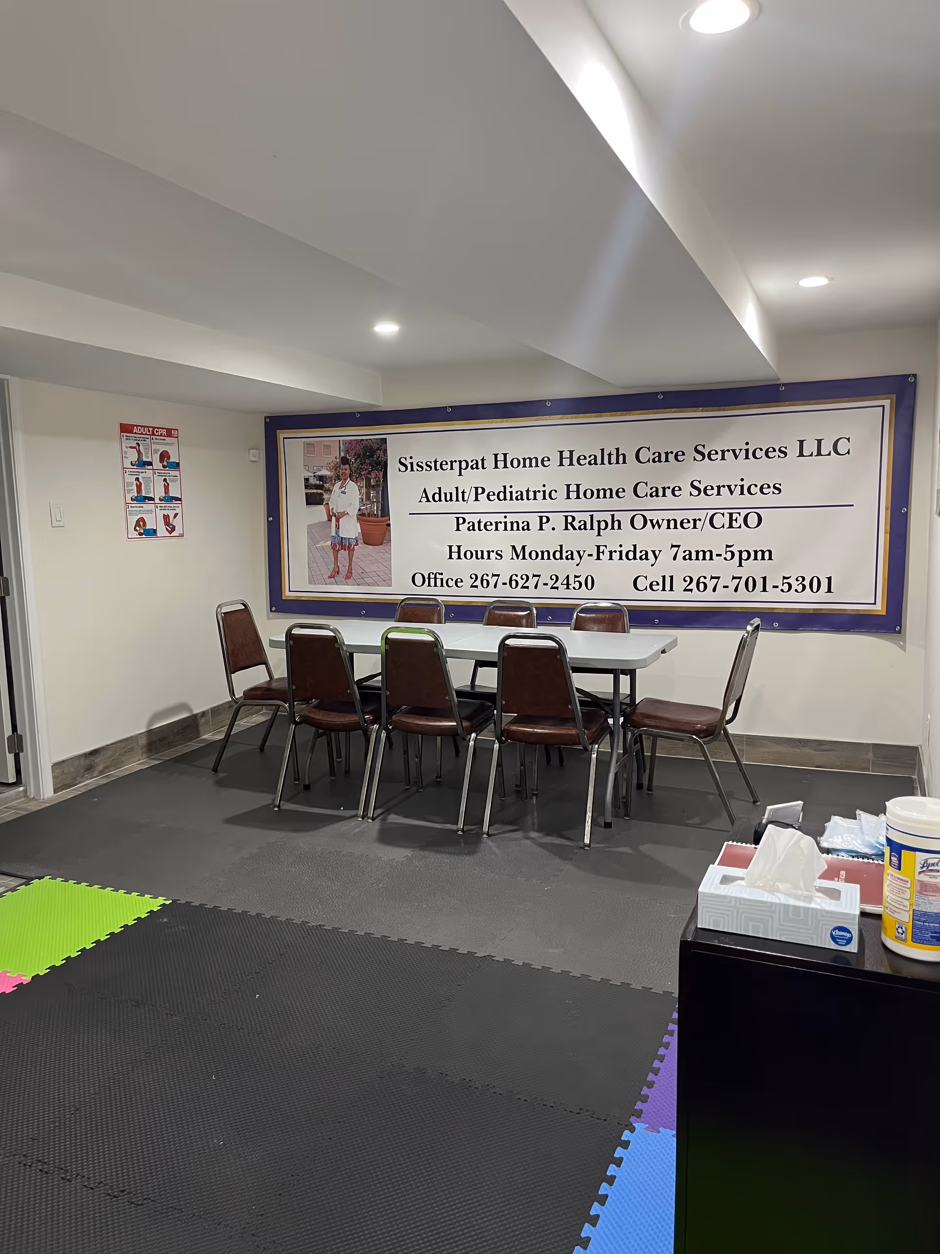 Interior room with a long conference table, chairs, and a large facility banner.