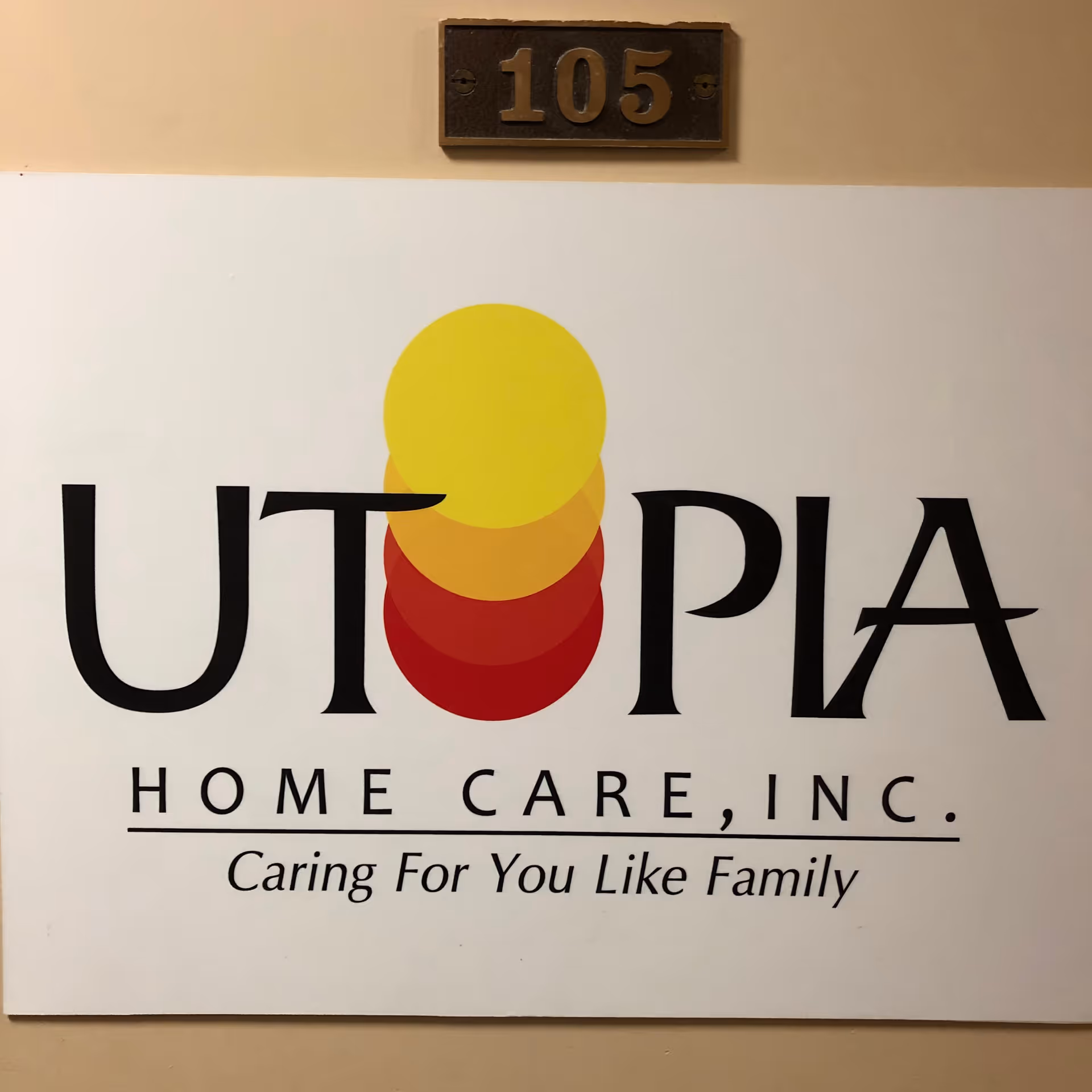 Interior wall sign for Utopia Home Care, Inc. with stacked yellow, orange, and red circles.