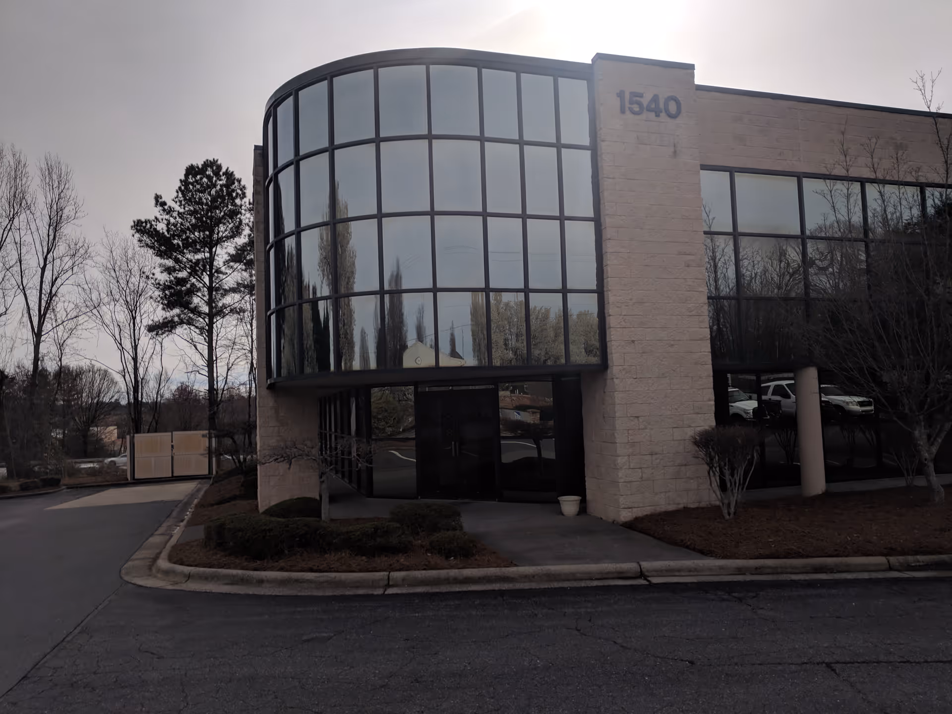 Exterior view of a glass-fronted building entrance with curved windows.