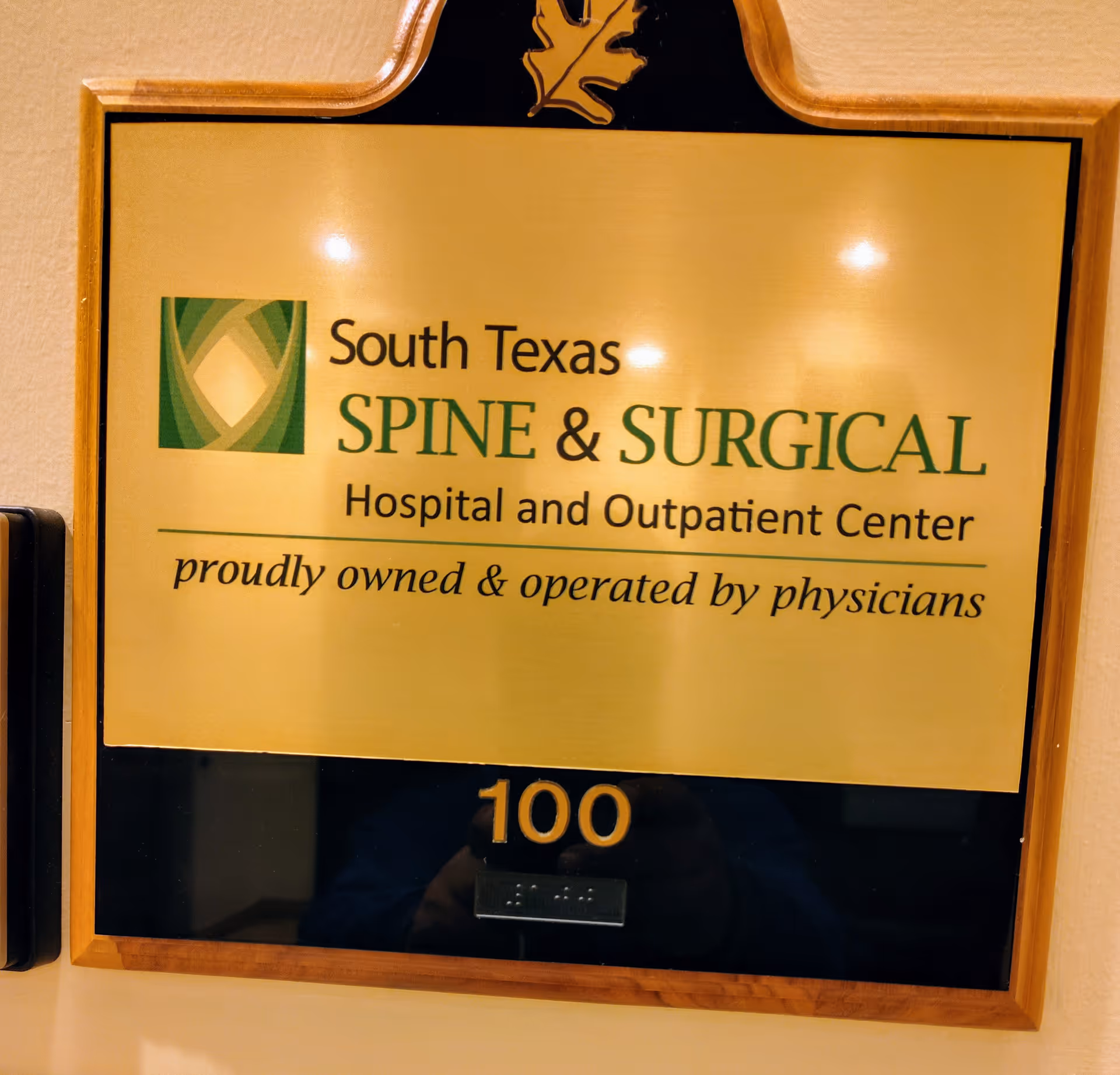 Gold plaque on a wall reads South Texas Spine & Surgical Hospital and Outpatient Center.