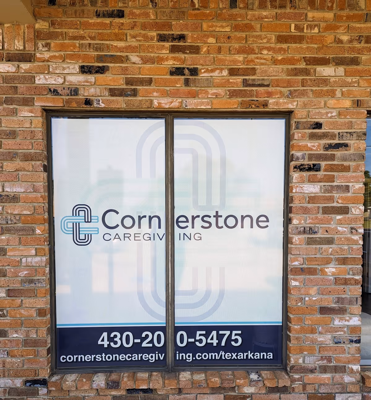 Brick exterior with a glass door displaying Cornerstone Caregiving signage.