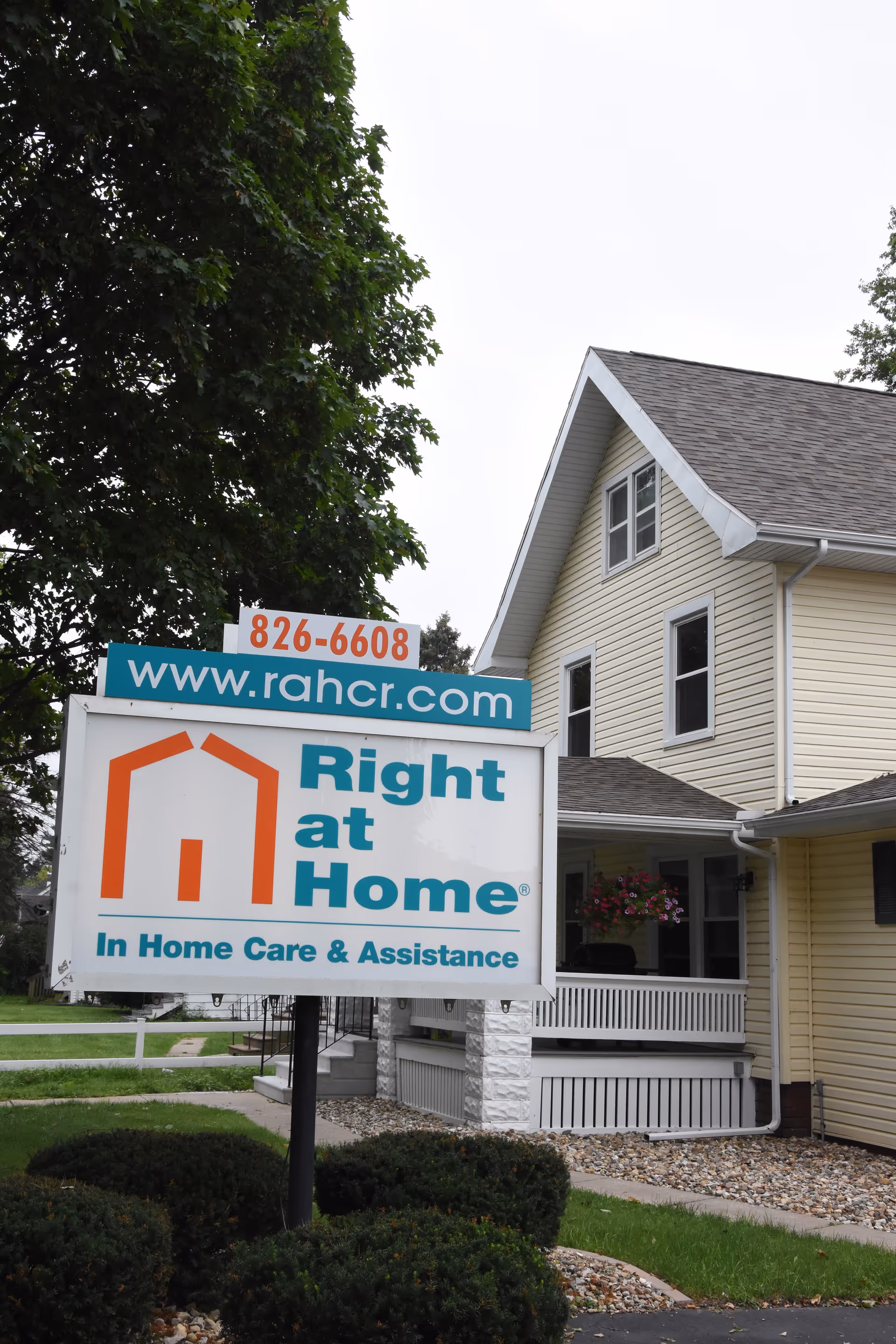Exterior view of a beige house with a large Right at Home sign.