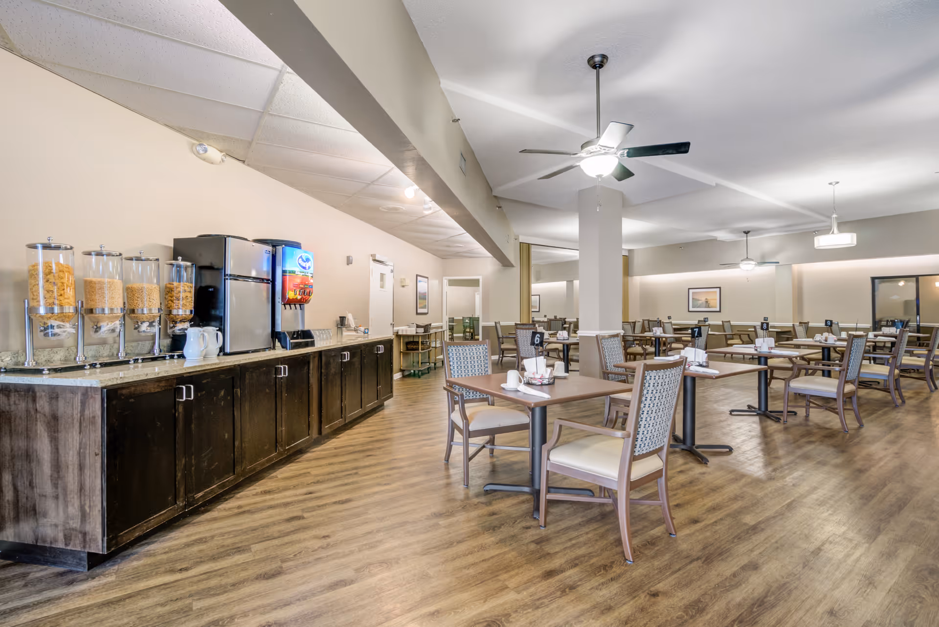 Senior living dining area with cereal dispensers and arranged tables.