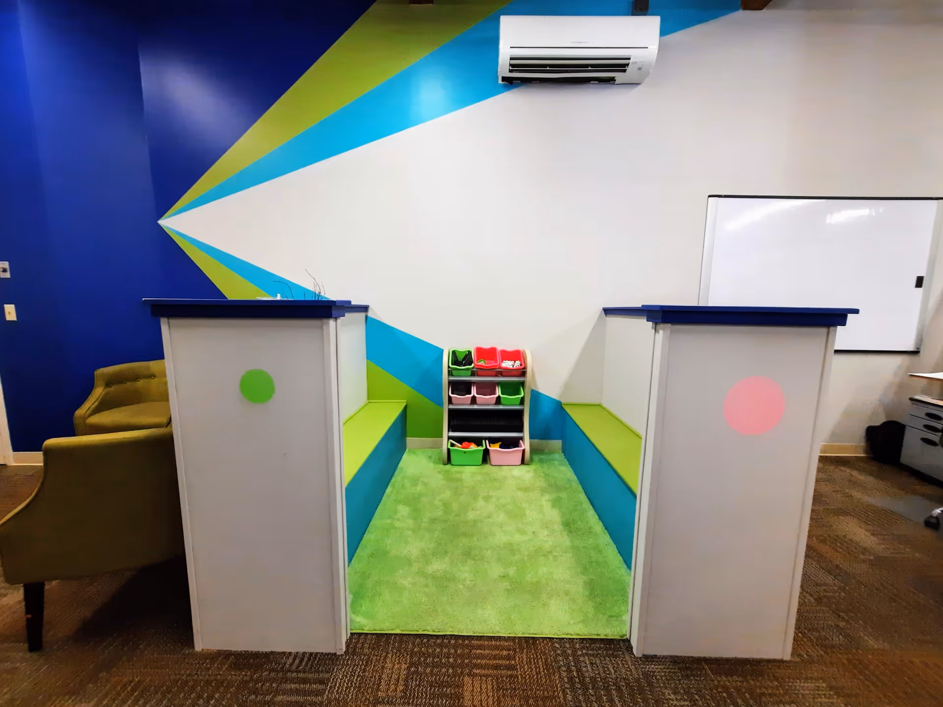 Colorful reception area with two white front counters, shoe cubbies, and bright geometric wall mural.