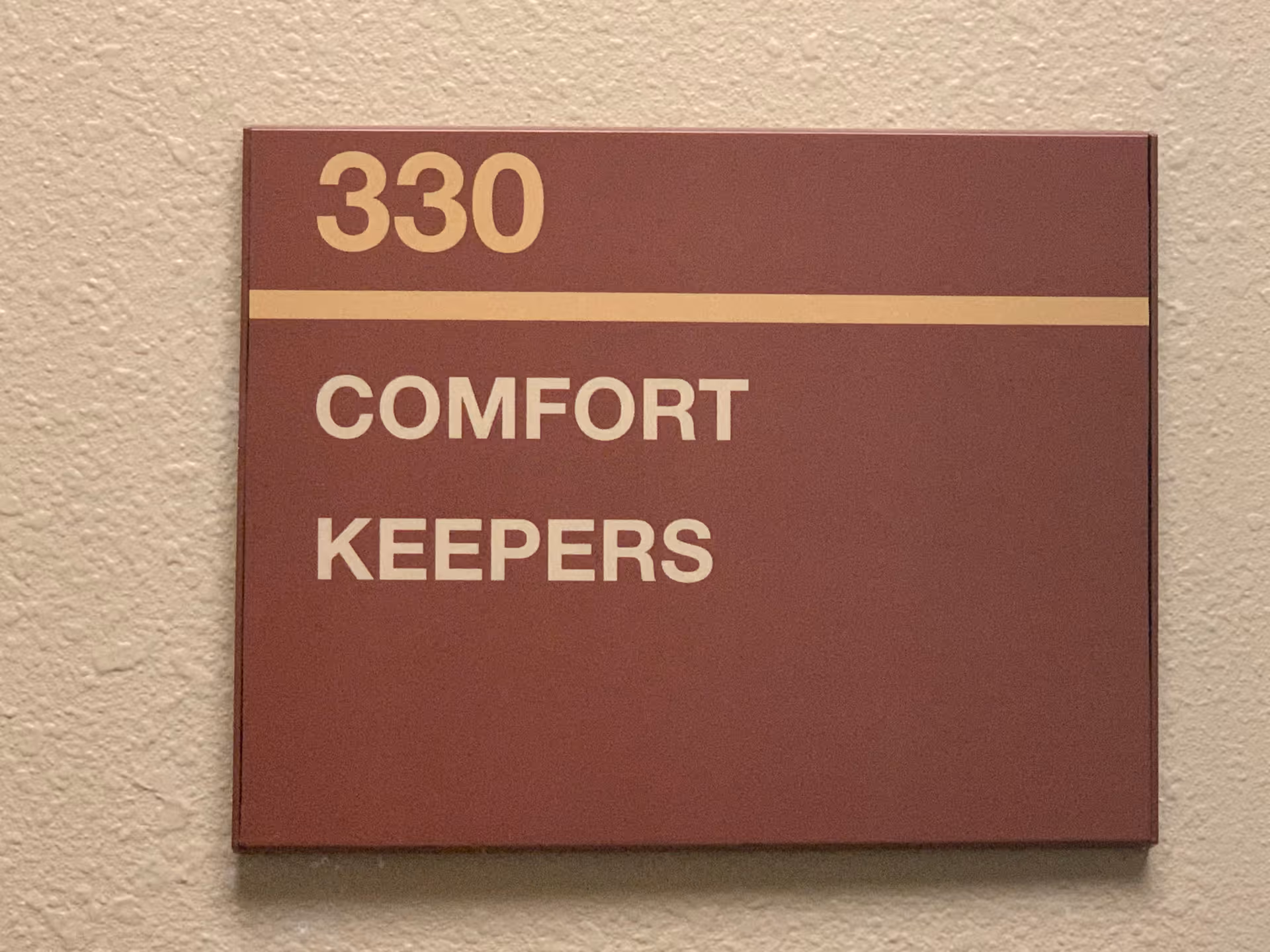 Interior hallway plaque displaying room 330 and Comfort Keepers.